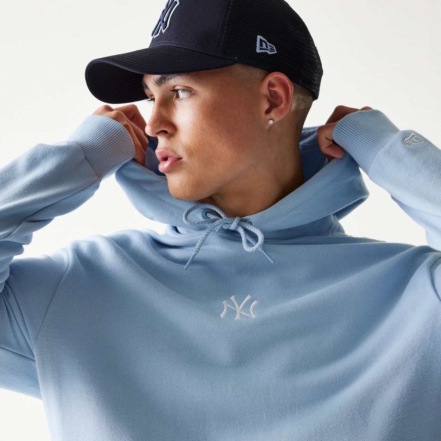 The model is wearing this MLB League Essential Midi New York Yankees Oversized Pullover Hoodie in pastel blue. 3