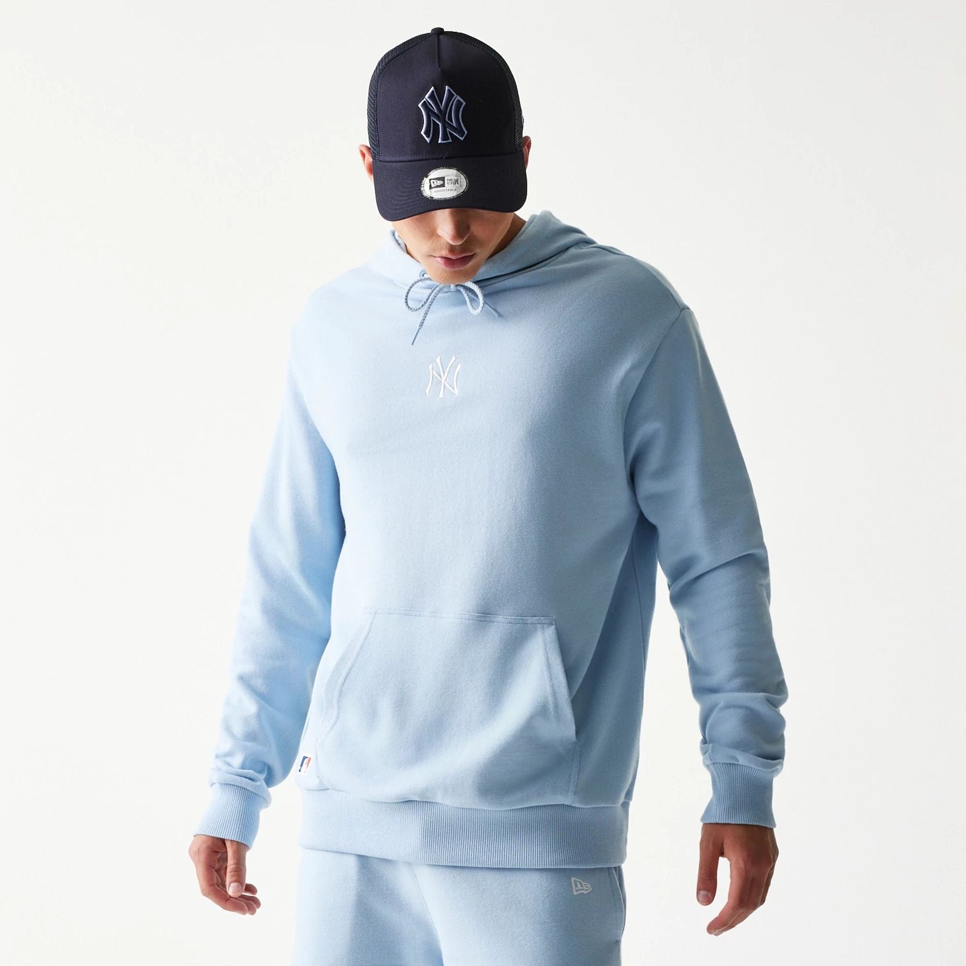 The model is wearing this MLB League Essential Midi New York Yankees Oversized Pullover Hoodie in pastel blue. 1