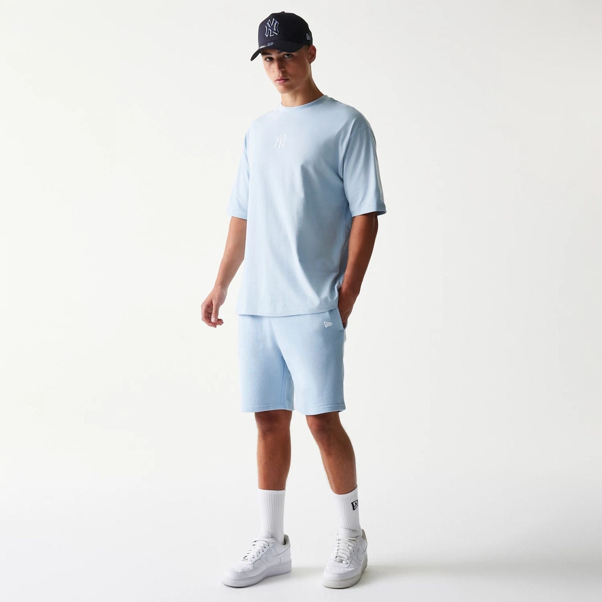 The model is wearing this MLB League Essential Midi New York Yankees Shorts in pastel blue. 8