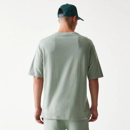 The model is wearing this MLB League Essential Midi LA Dodgers Oversized T-Shirt in pastel green. 2