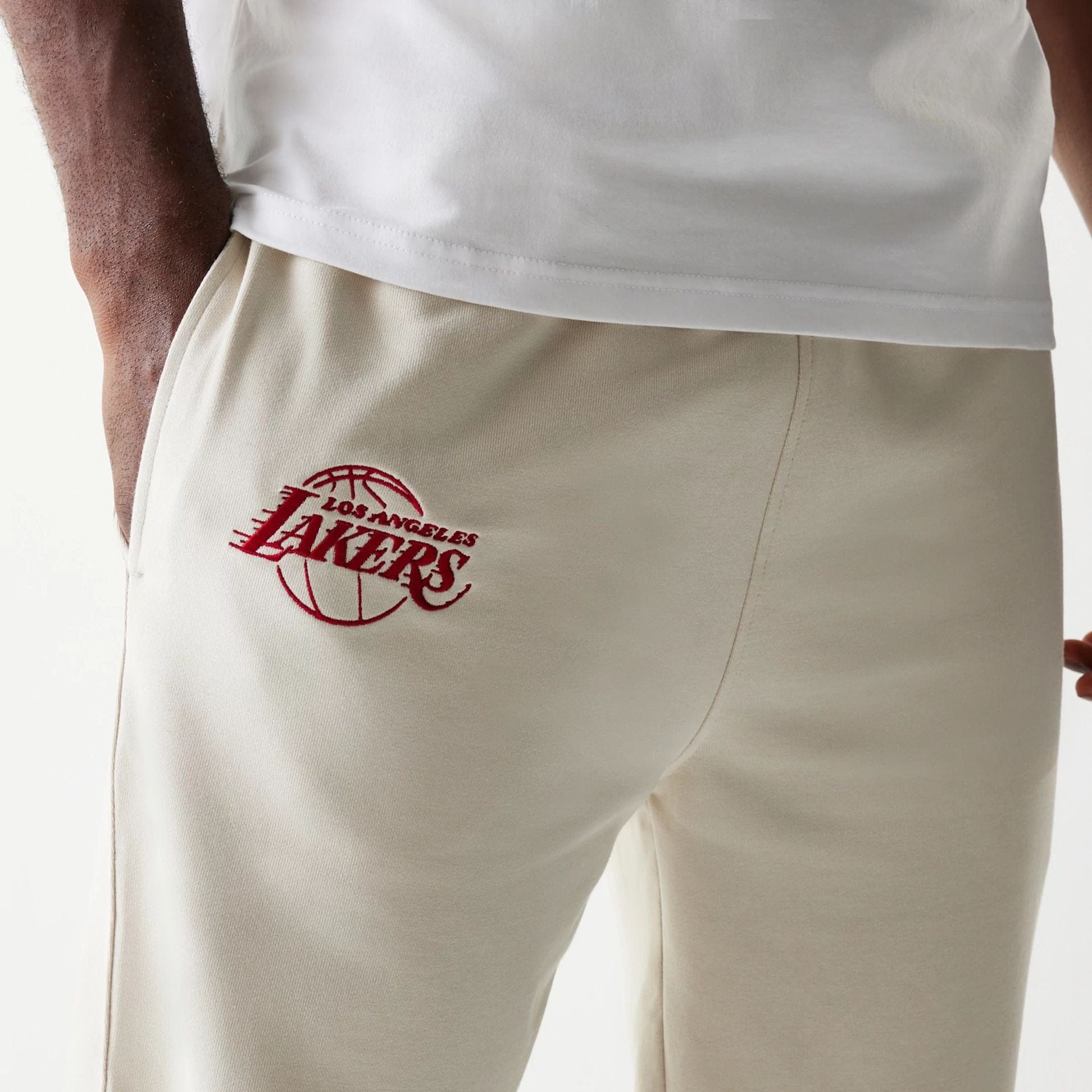 The model is wearing this NBA League Essential LA Lakers Joggers in cream. 4