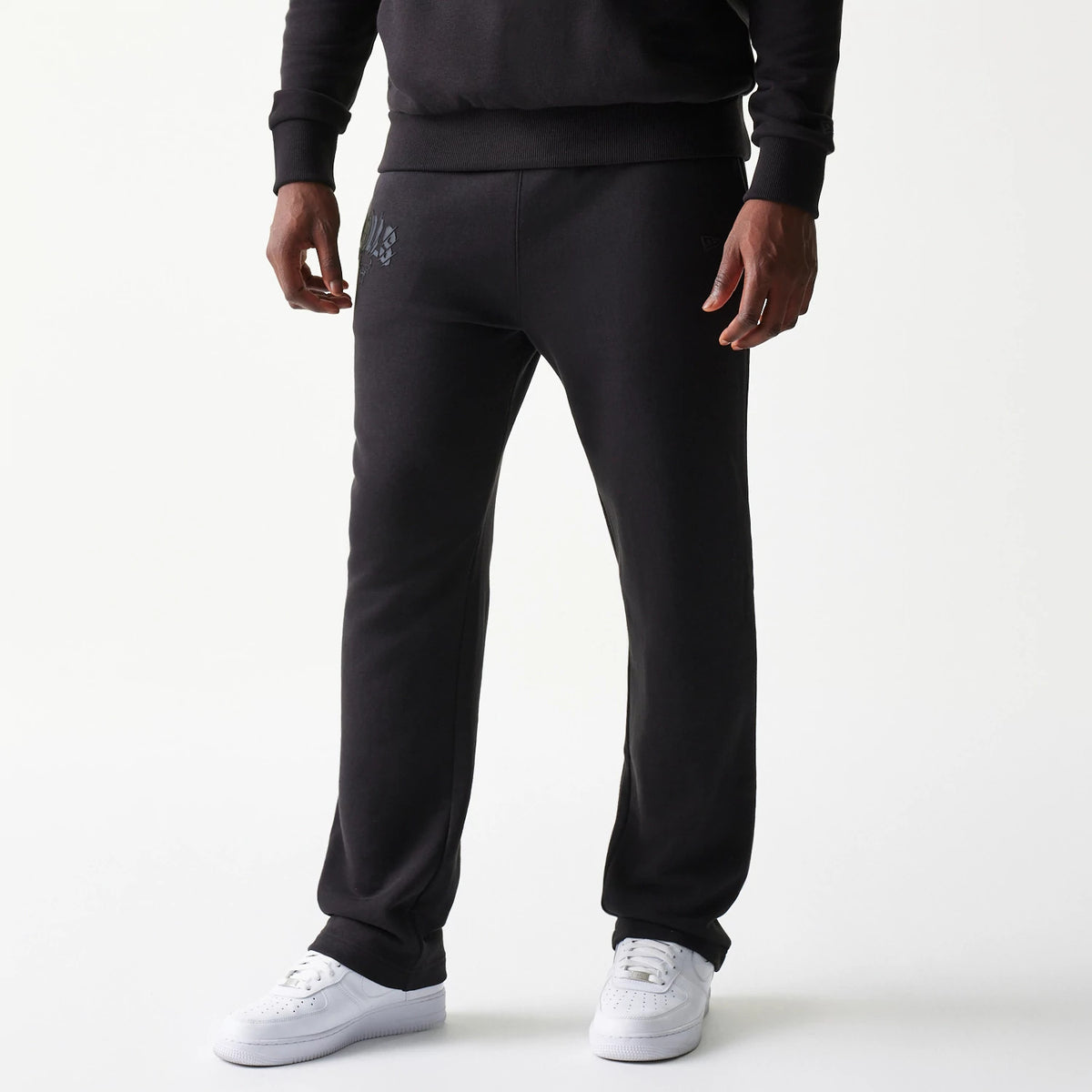 New Era Chicago Bulls NBA Black Straight Leg Joggers, front view on a model with grey team logo detail on the left pocket and white trainers, showcasing the simple straight leg cut and ribbed waistband.
