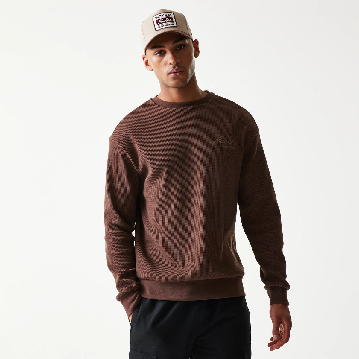 The model is wearing this New Era Script Waffle Crew Neck Sweater in brown. 3