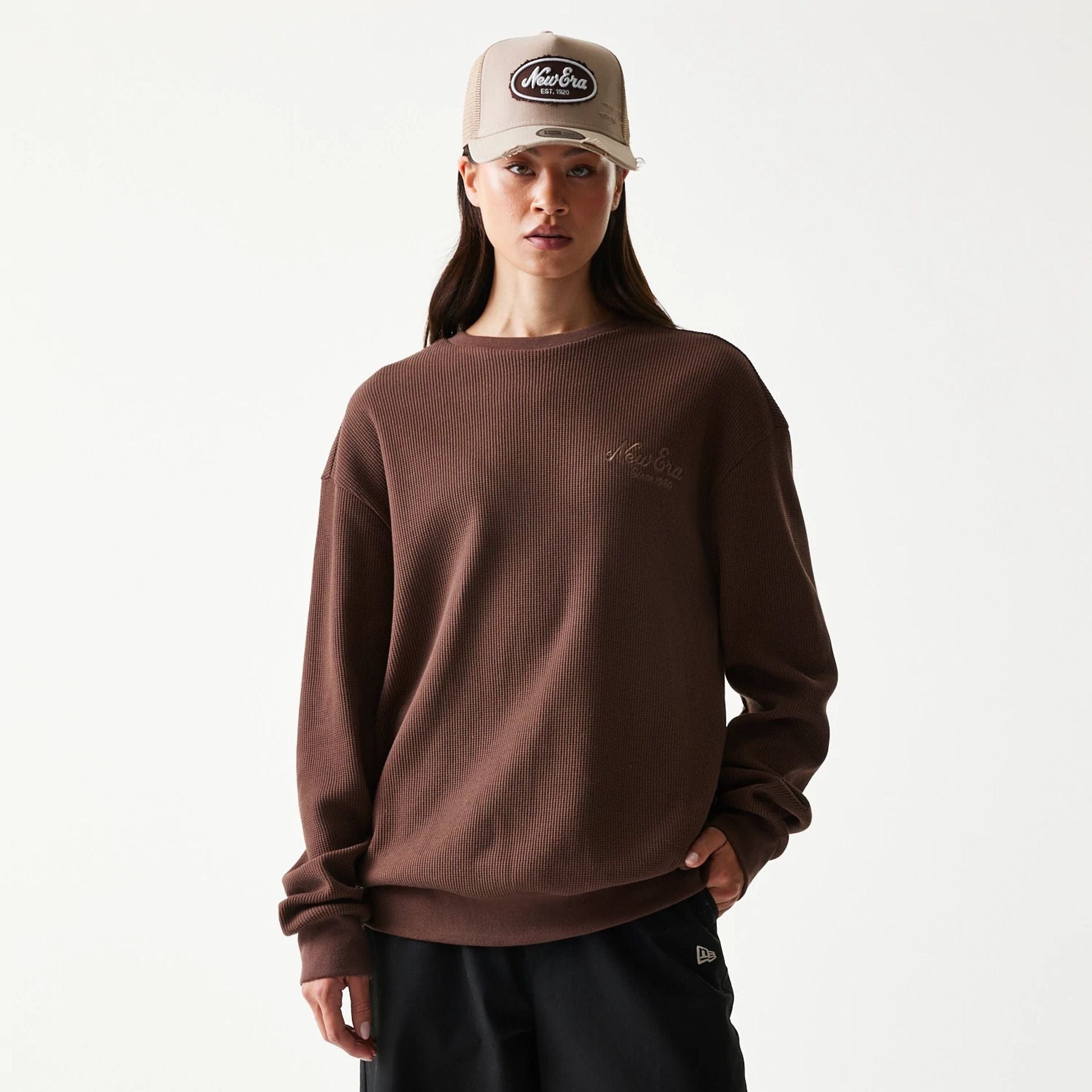 The model is wearing this New Era Script Waffle Crew Neck Sweater in brown. 4