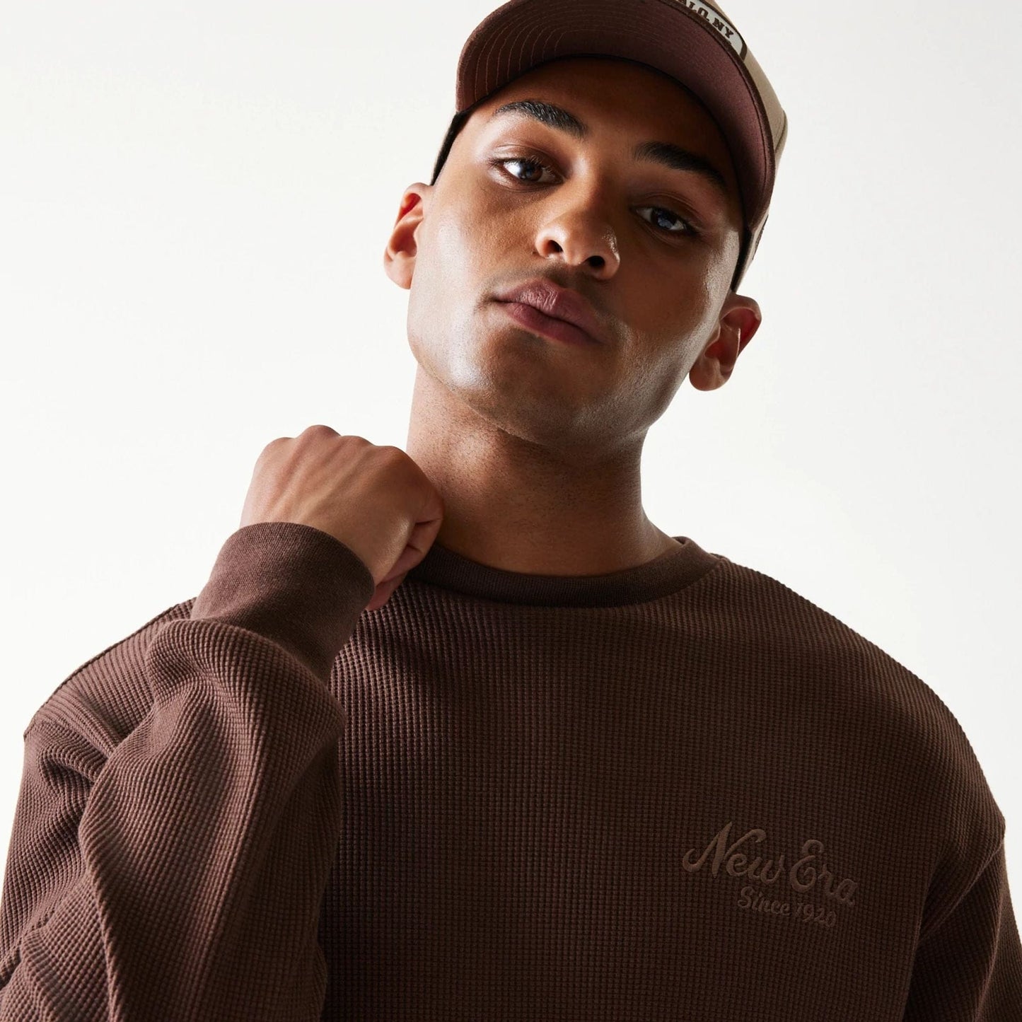 The model is wearing this New Era Script Waffle Crew Neck Sweater in brown. 8