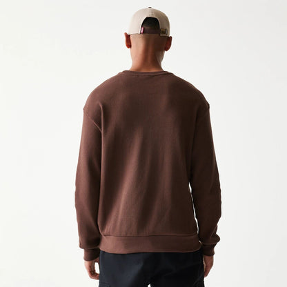 The model is wearing this New Era Script Waffle Crew Neck Sweater in brown. 2