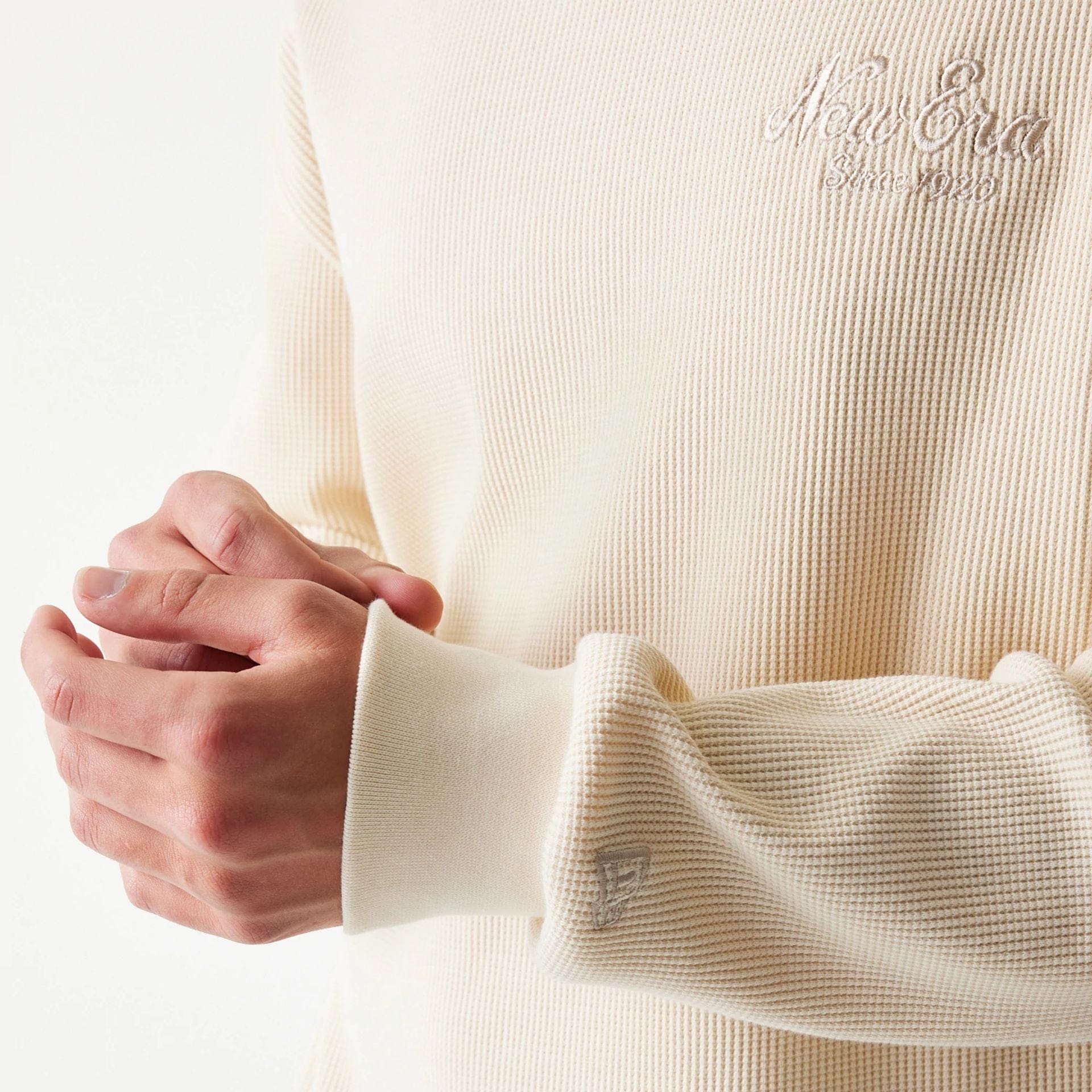 The model is wearing this New Era Script Waffle Crew Neck Sweater in light beige. 6