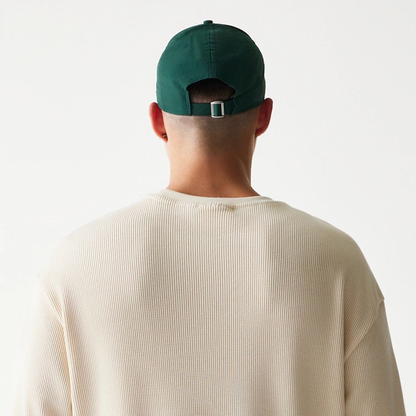 The model is wearing this New Era Script Waffle Crew Neck Sweater in light beige. 7