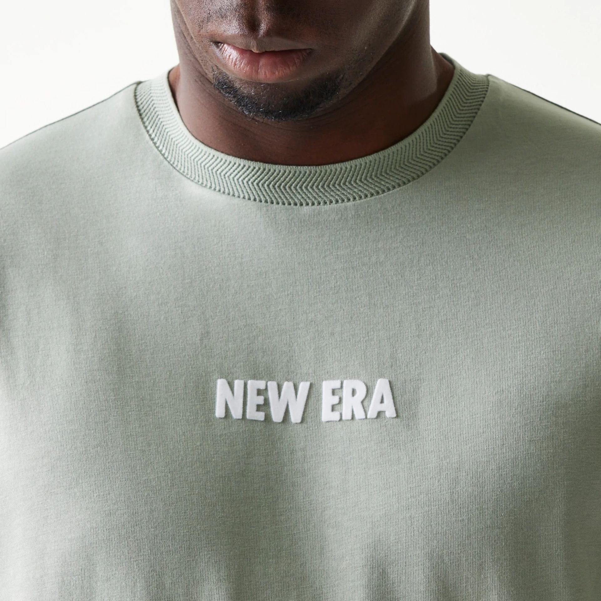 The model is wearing this New Era Graphic Oversized T-Shirt in pastel green. 6