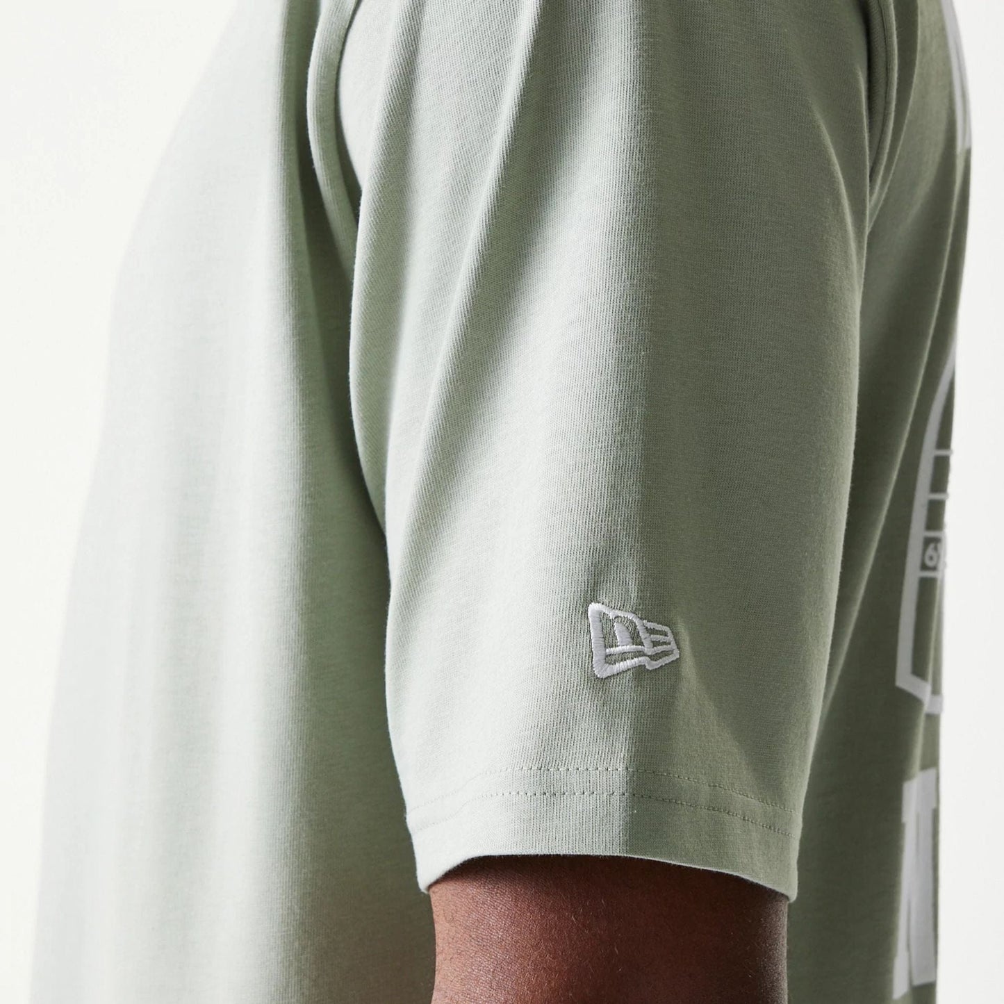 The model is wearing this New Era Graphic Oversized T-Shirt in pastel green. 7