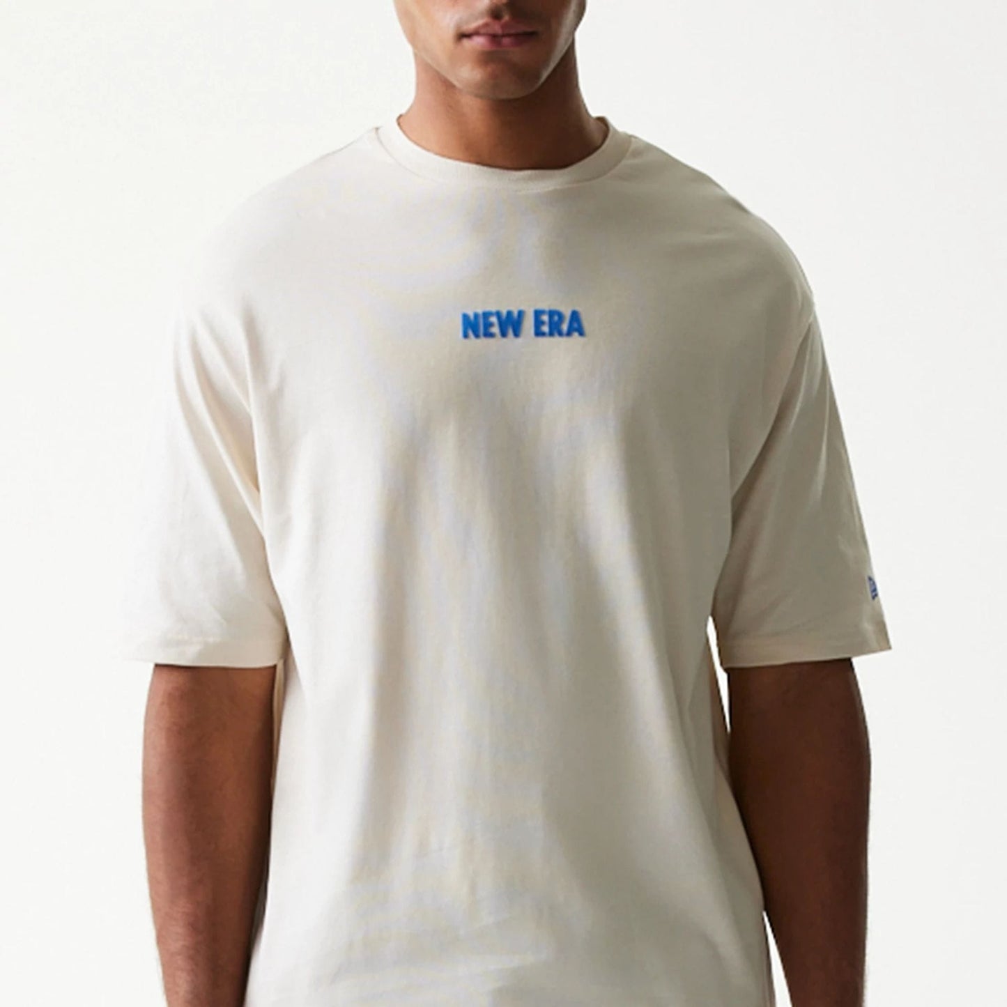 The model is wearing this New Era Graphic Oversized T-Shirt in light beige. 5