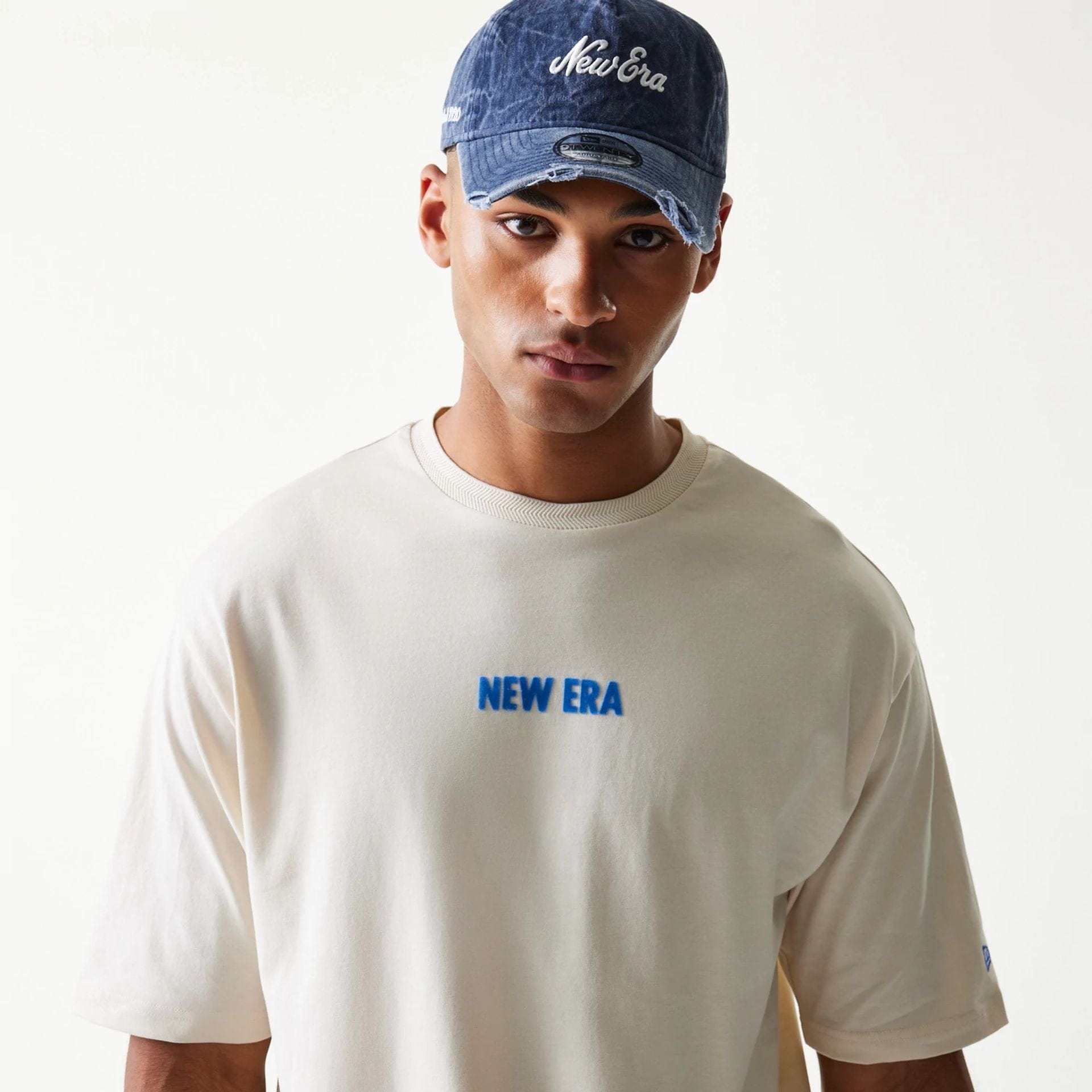 The model is wearing this New Era Graphic Oversized T-Shirt in light beige. 7