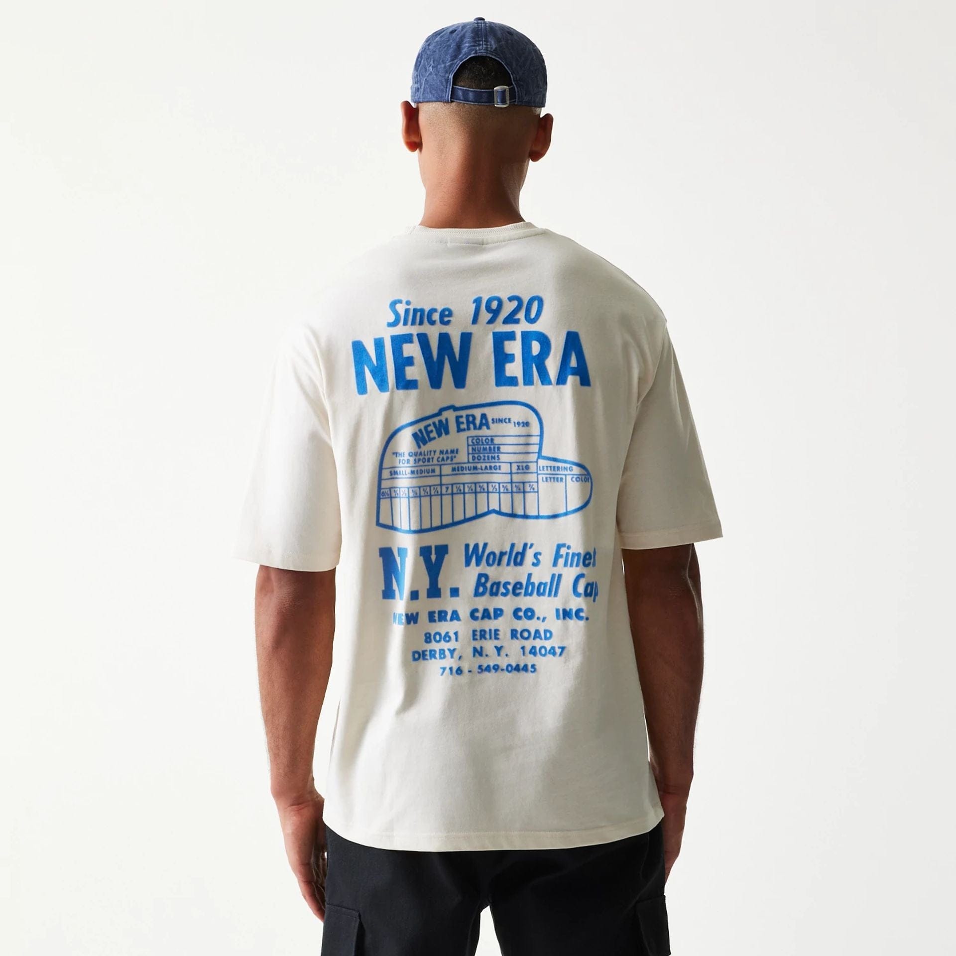 The model is wearing this New Era Graphic Oversized T-Shirt in light beige. 2