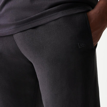 New Era Chicago Bulls NBA Black Shorts, front view showing the black design with a discreet printed New Era logo near the pocket, styled casually with the hand in the pocket for a relaxed look.