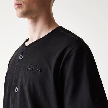 The model is wearing this New Era Open Heritage Script T-Shirt in black. 4