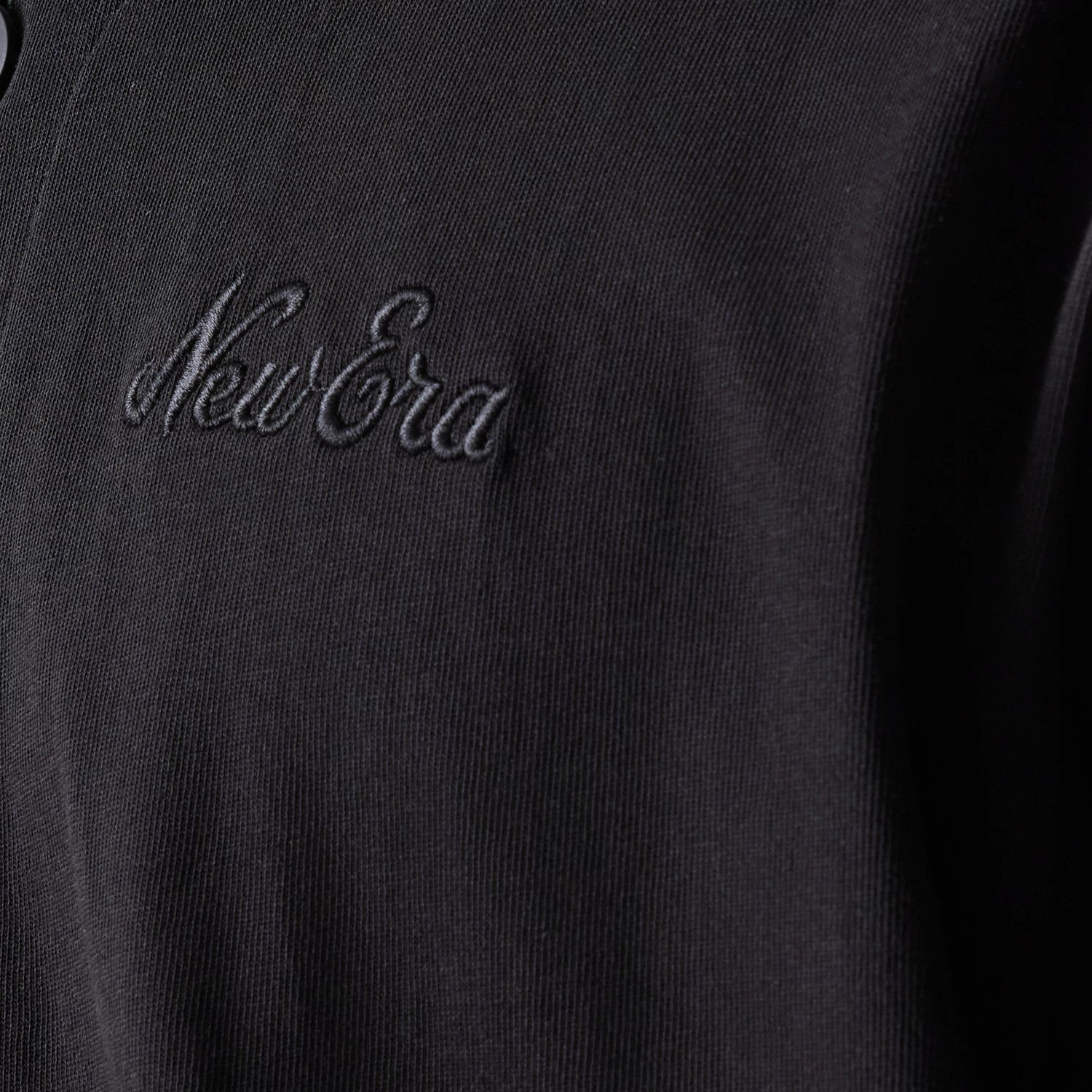 The model is wearing this New Era Open Heritage Script T-Shirt in black. 5