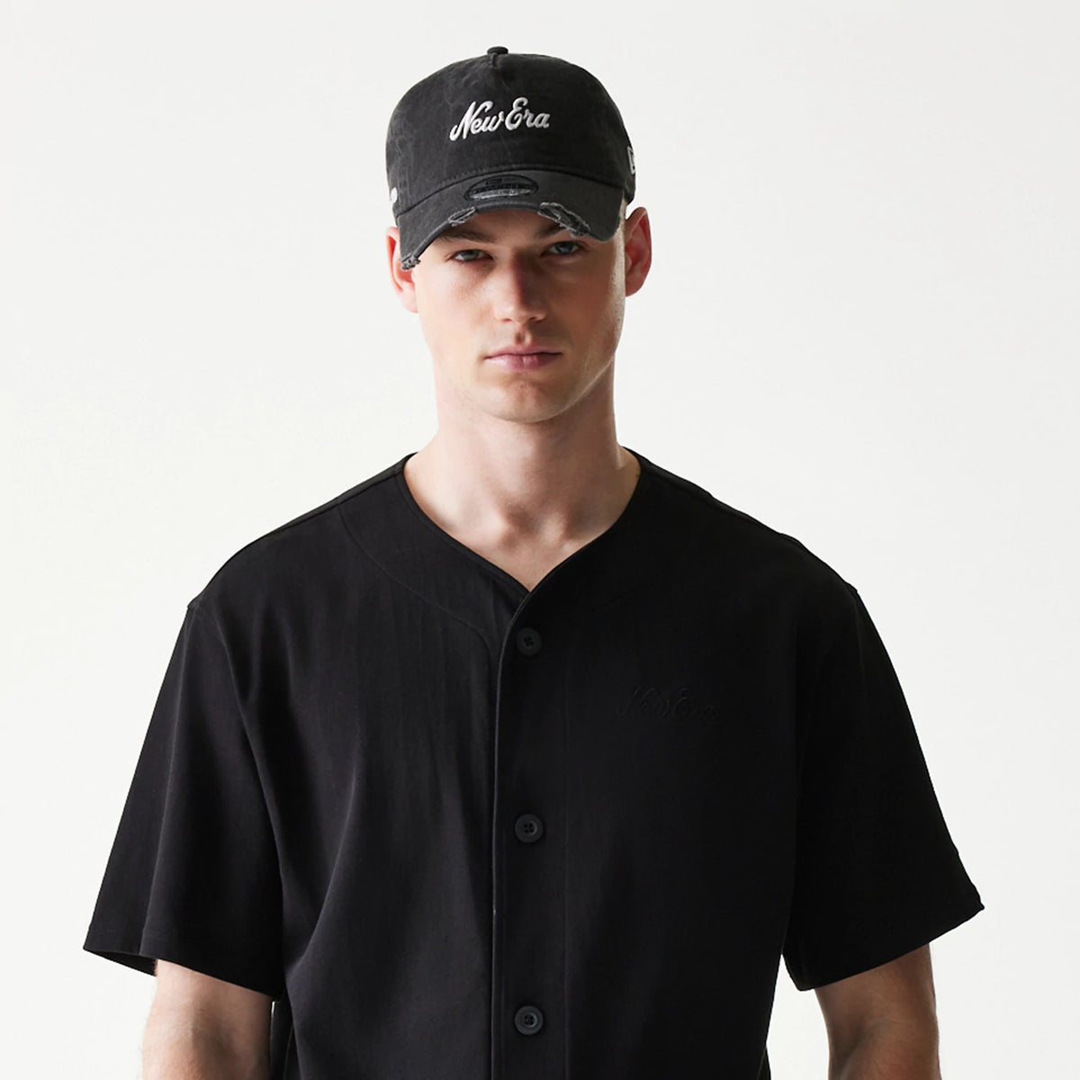 The model is wearing this New Era Open Heritage Script T-Shirt in black. 6