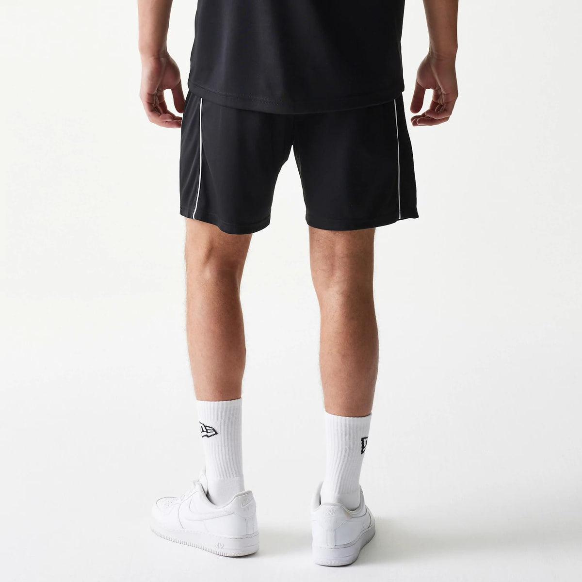 The model is wearing this New Era Football Shorts in black. 2