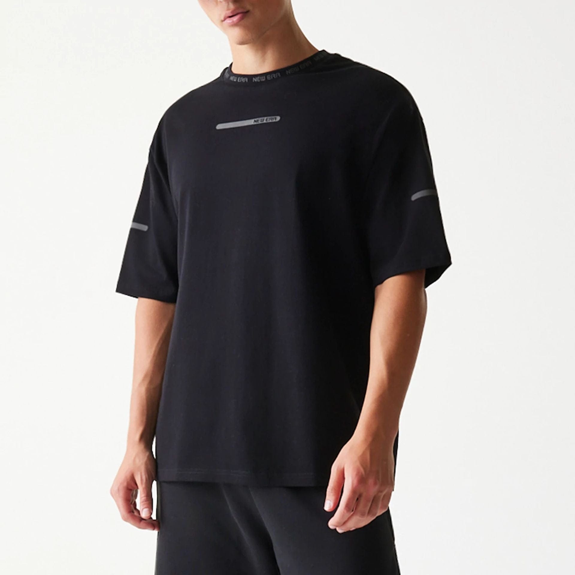 The model is wearing this New Era Tech Oversized T-Shirt in black. 3