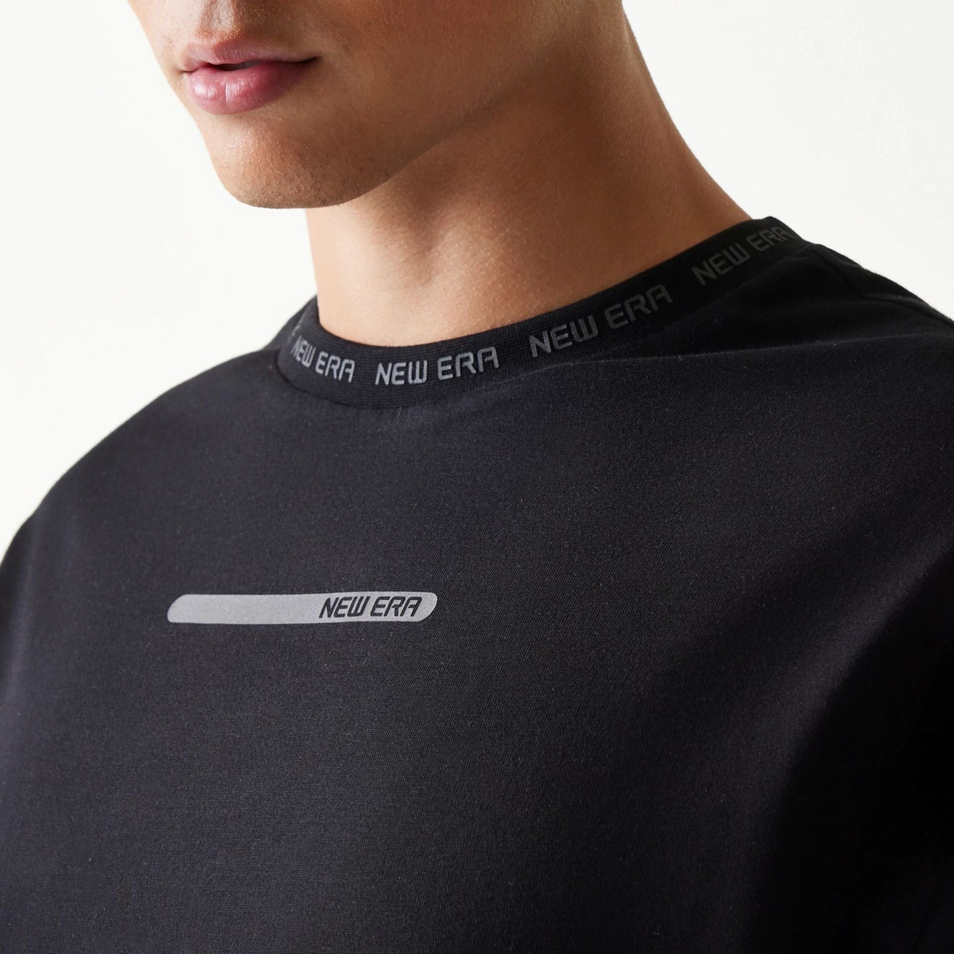 The model is wearing this New Era Tech Oversized T-Shirt in black. 4