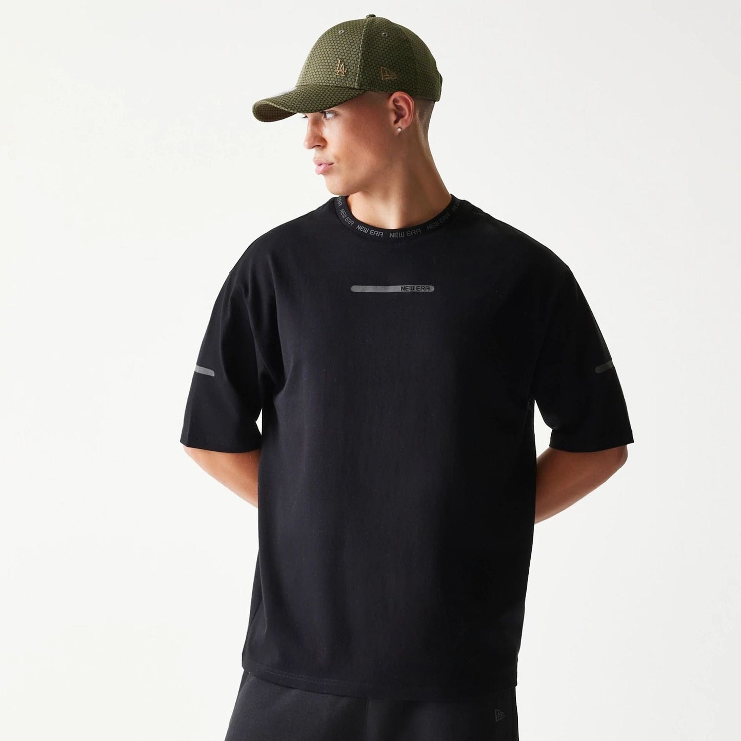 The model is wearing this New Era Tech Oversized T-Shirt in black. 1