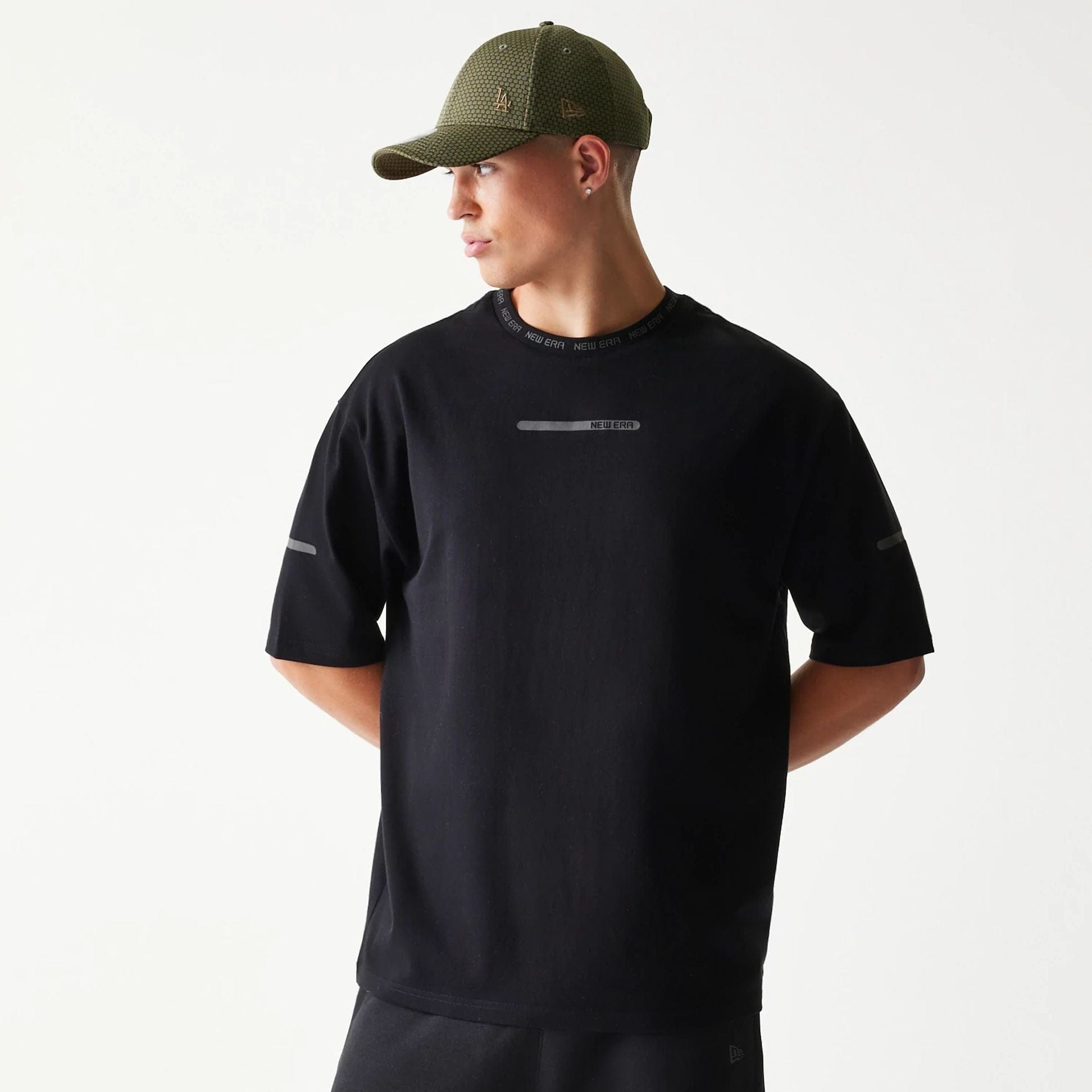 The model is wearing this New Era Tech Oversized T-Shirt in black. 1