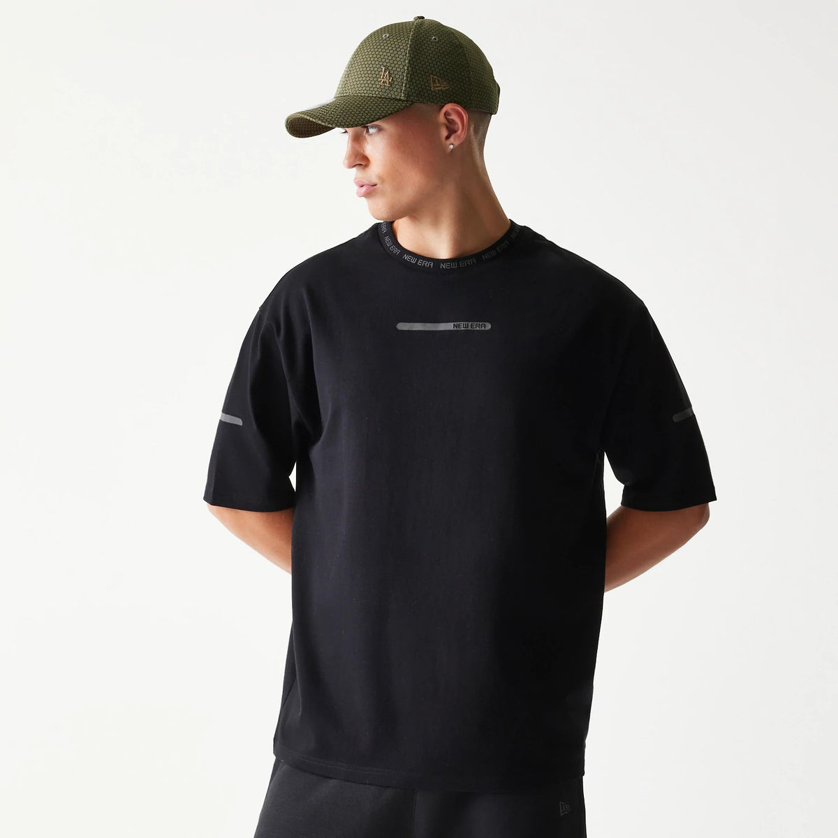 The model is wearing this New Era Tech Oversized T-Shirt in black. 1