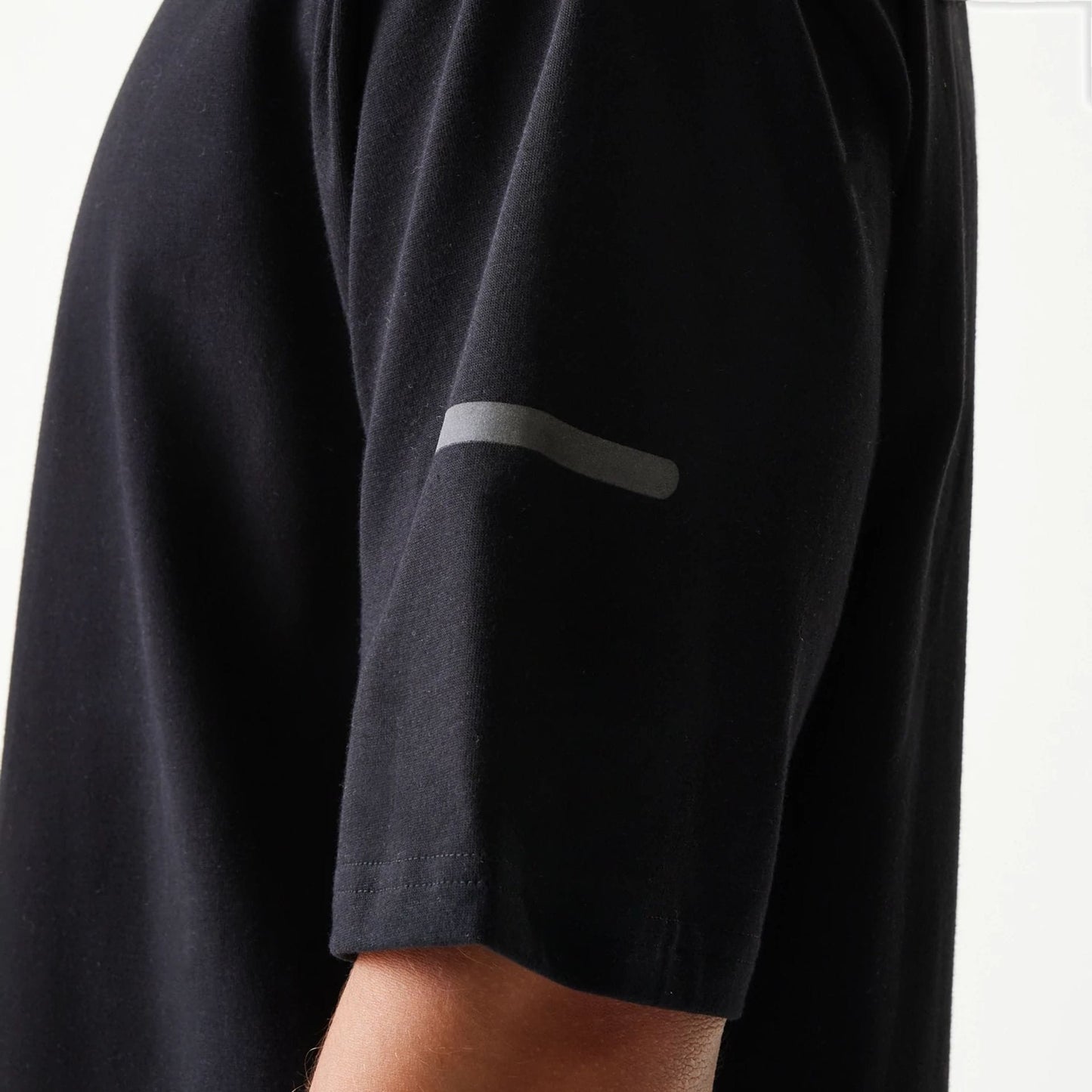 The model is wearing this New Era Tech Oversized T-Shirt in black. 6