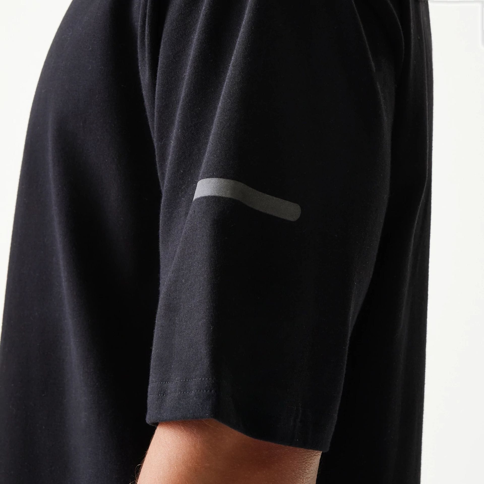 The model is wearing this New Era Tech Oversized T-Shirt in black. 6