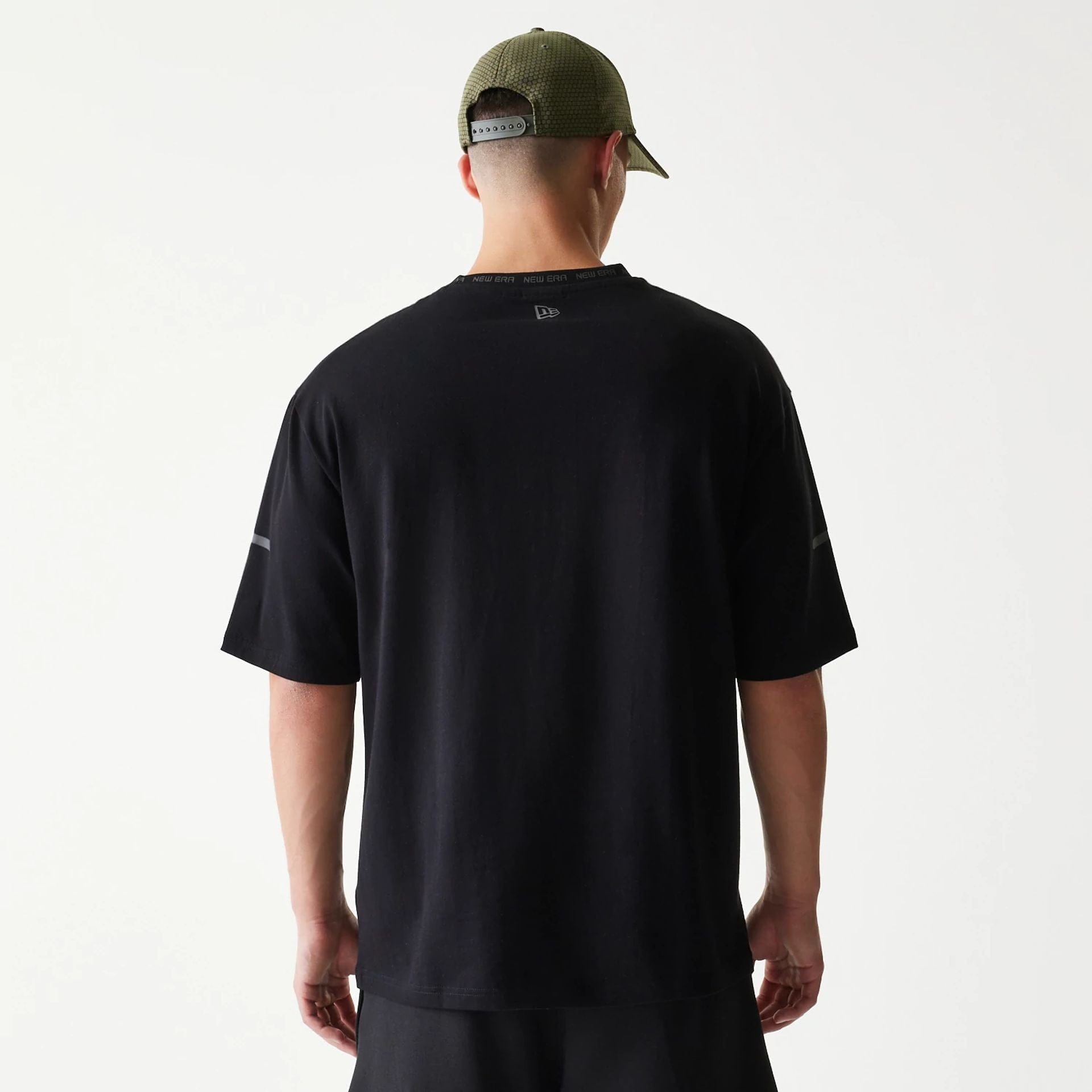 The model is wearing this New Era Tech Oversized T-Shirt in black. 2