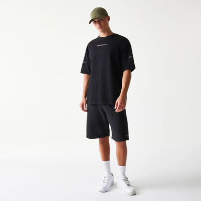 The model is wearing this New Era Tech Oversized T-Shirt in black. 8