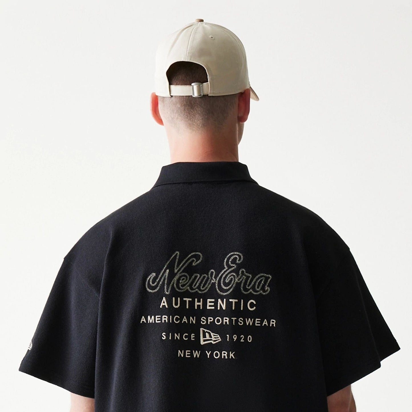 The model is wearing this New Era Graphic Polo T-Shirt in black. 7