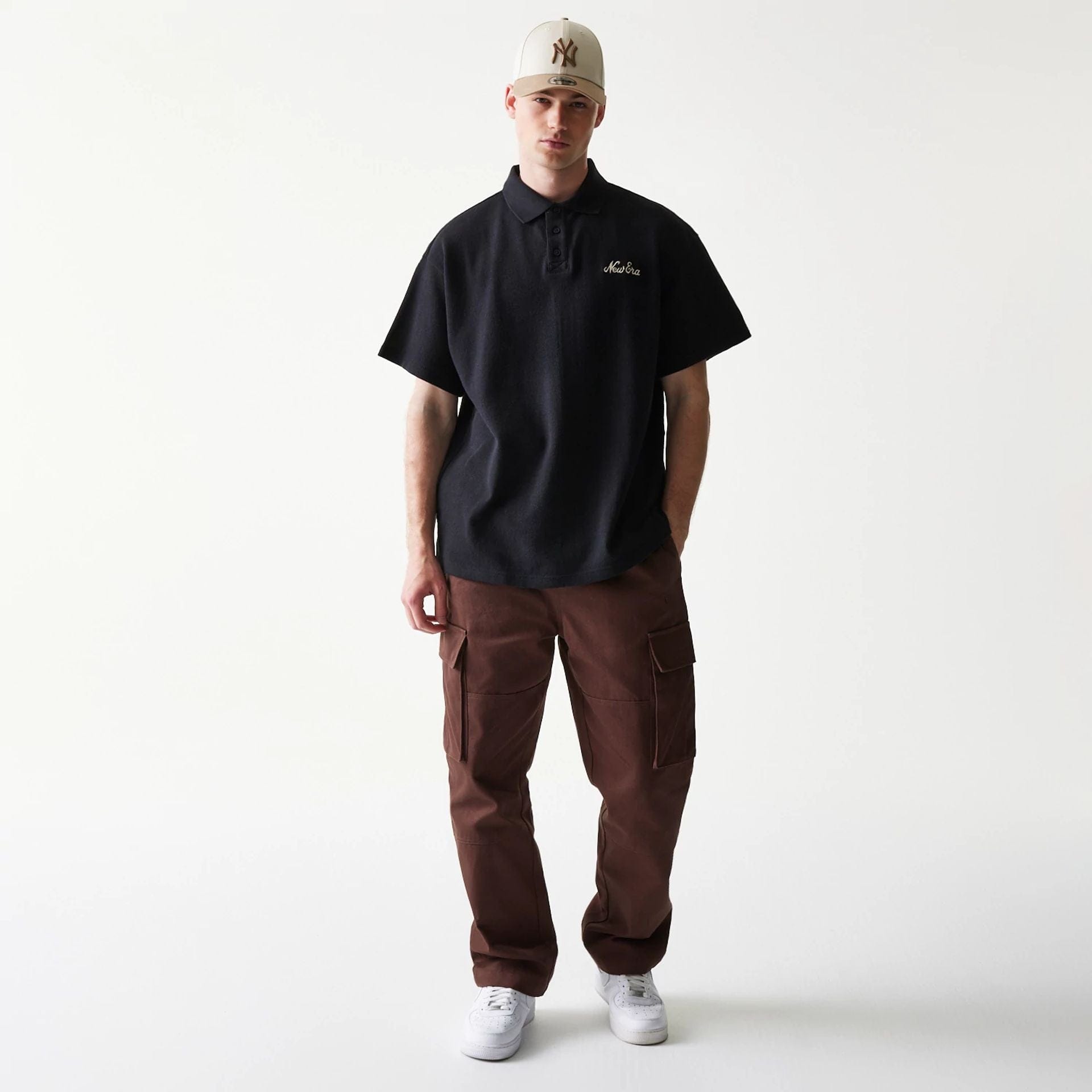 The model is wearing this New Era Graphic Polo T-Shirt in black. 8