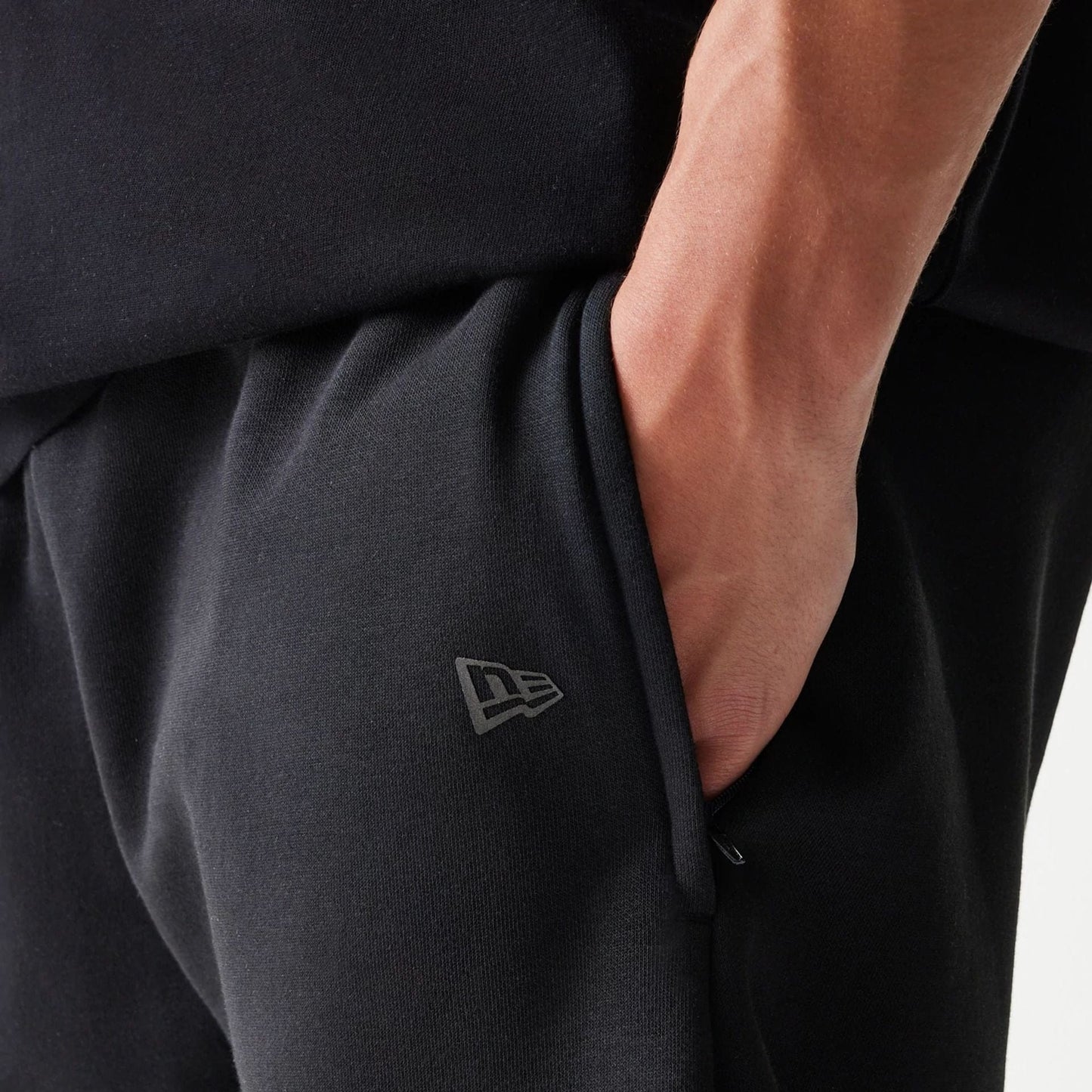 The model is wearing this New Era Tech Shorts in black. 4