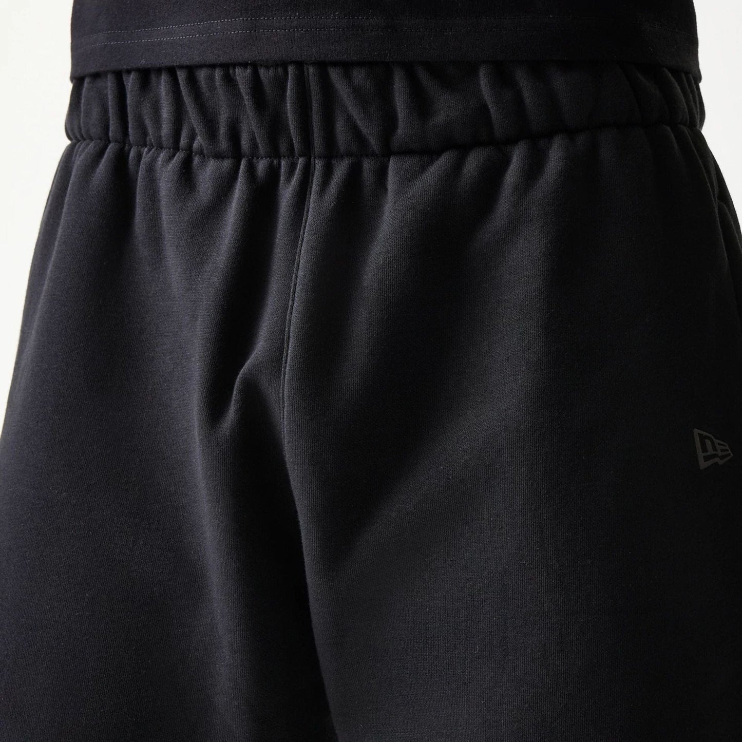 The model is wearing this New Era Tech Shorts in black. 5