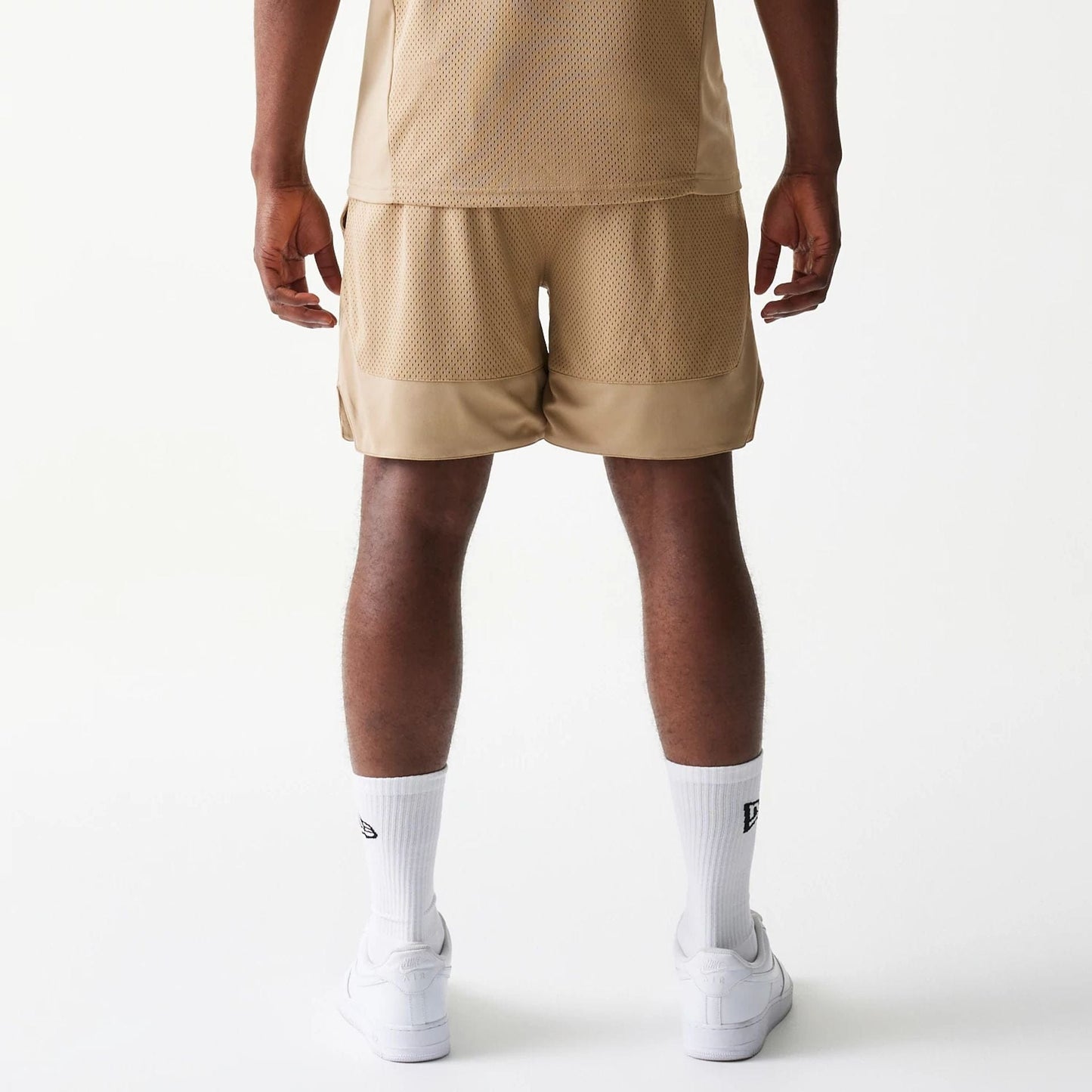 The model is wearing this New Era Mesh Graphic Oversized Shorts in light beige. 2