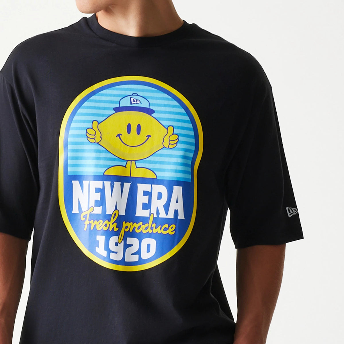 New Era Lemon Fruit Graphic Black Oversized T-Shirt, front view showing a large colourful lemon design with a smiley face and New Era Fresh produce 1920 text, with an embroidered New Era logo on the sleeve.