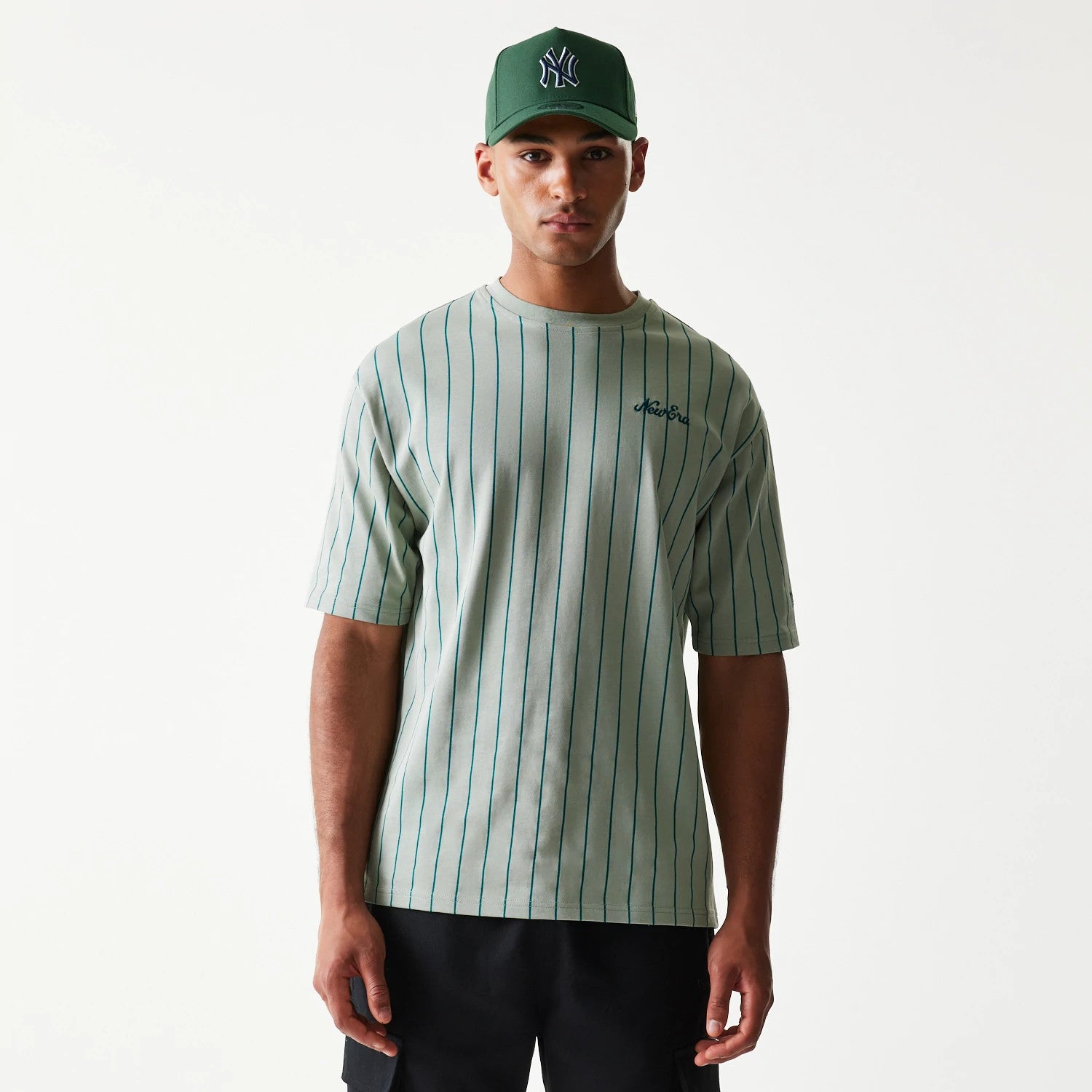 The model is wearing this New Era Pinstripe Oversized T-Shirt in pastel green. 1