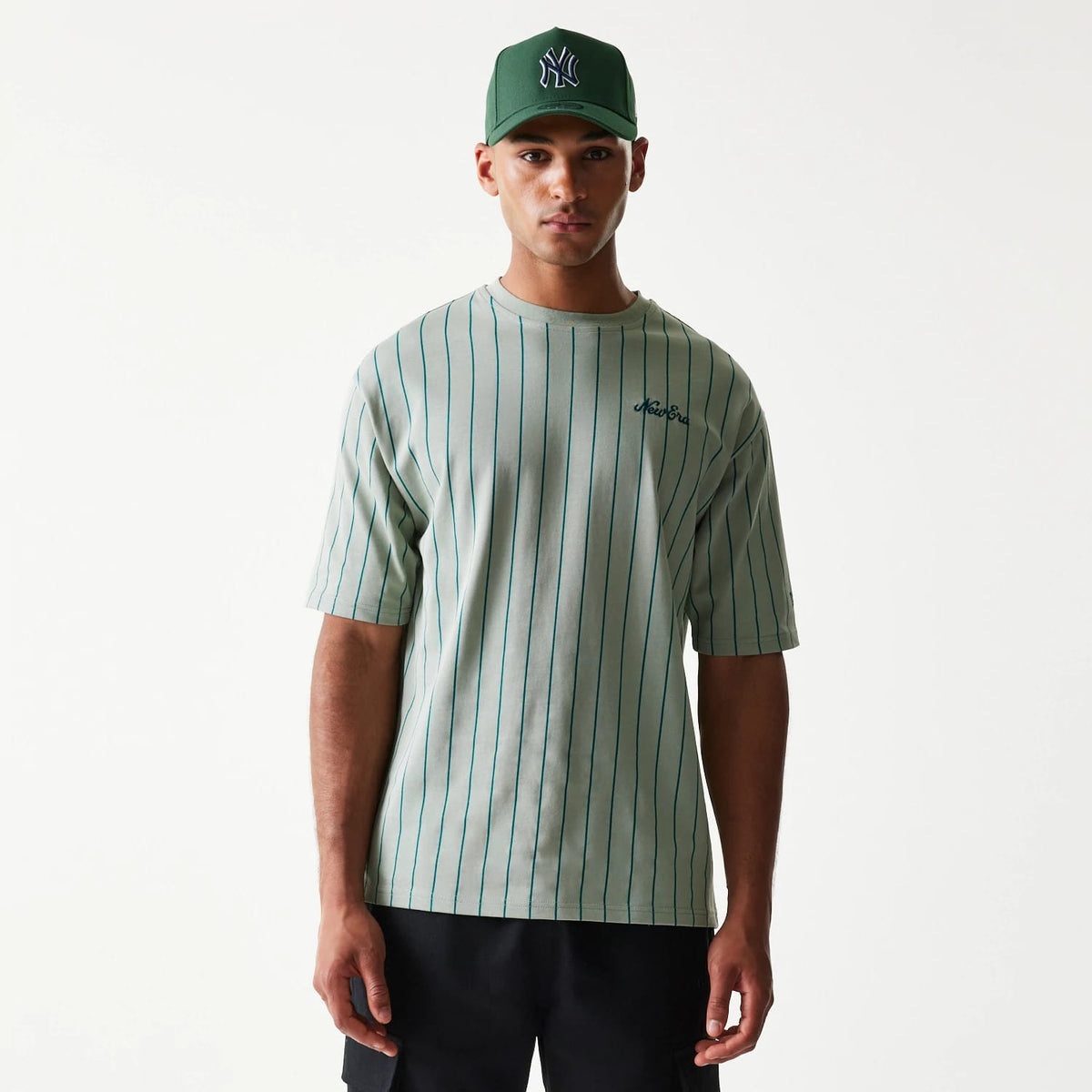 The model is wearing this New Era Pinstripe Oversized T-Shirt in pastel green. 1