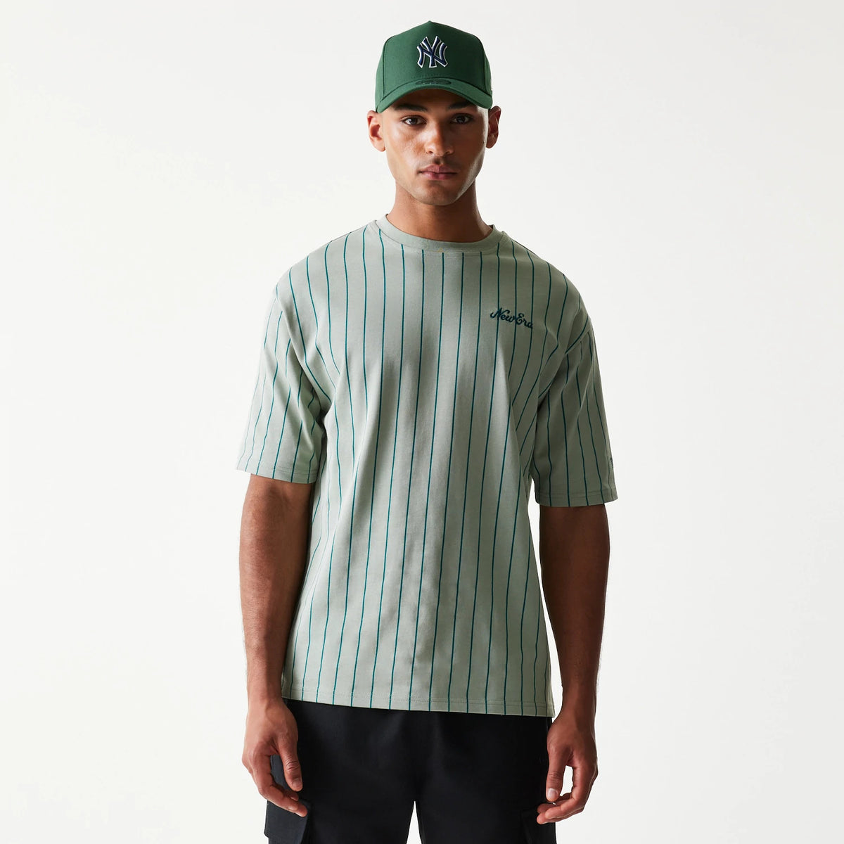 The model is wearing this New Era Pinstripe Oversized T-Shirt in pastel green. 1