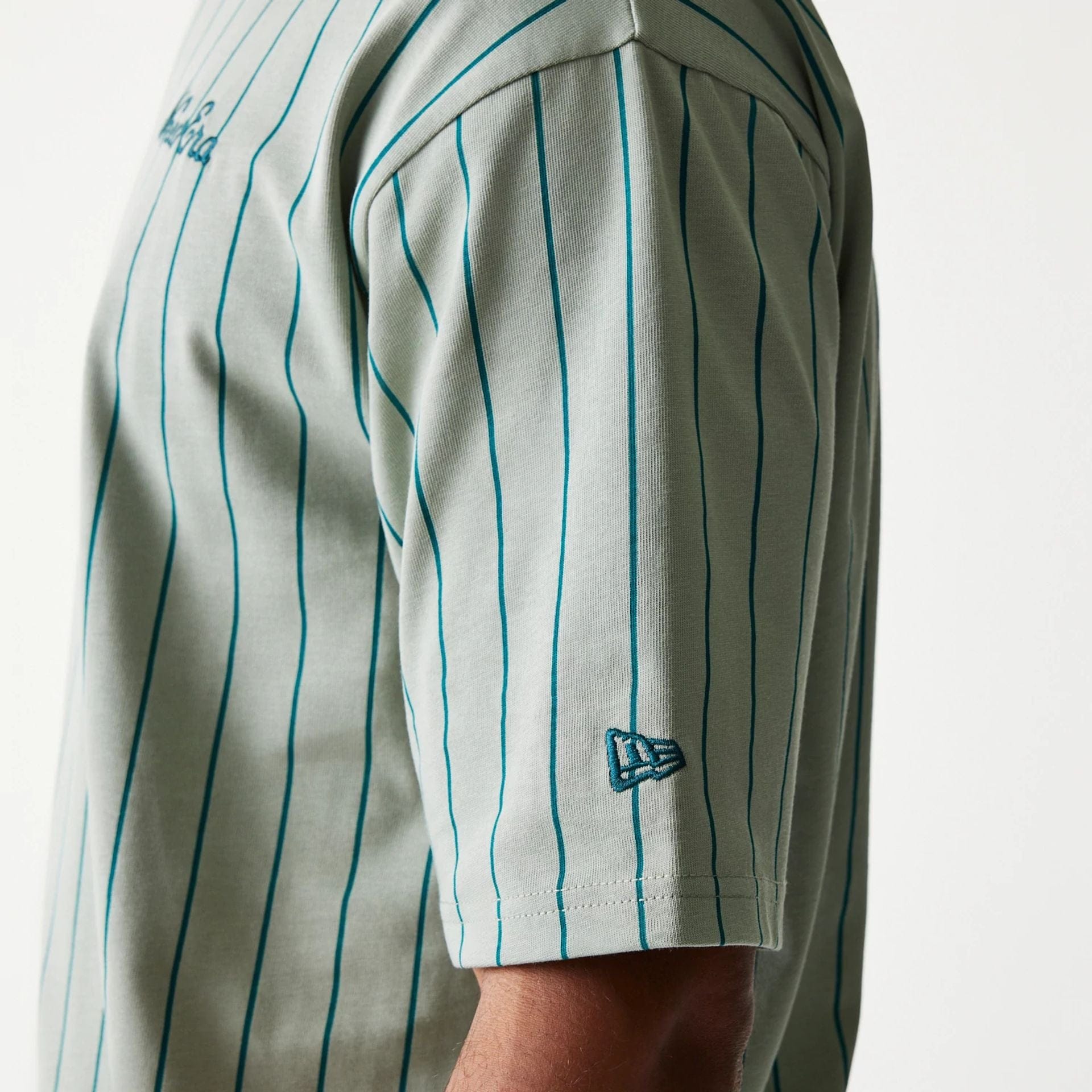 The model is wearing this New Era Pinstripe Oversized T-Shirt in pastel green. 5
