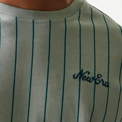 New Era Pinstripe Pastel Green Oversized T-Shirt, front view showing narrow dark green pinstripes running vertically down the shirt and an embroidered New Era logo in dark green positioned on the left side of the chest.