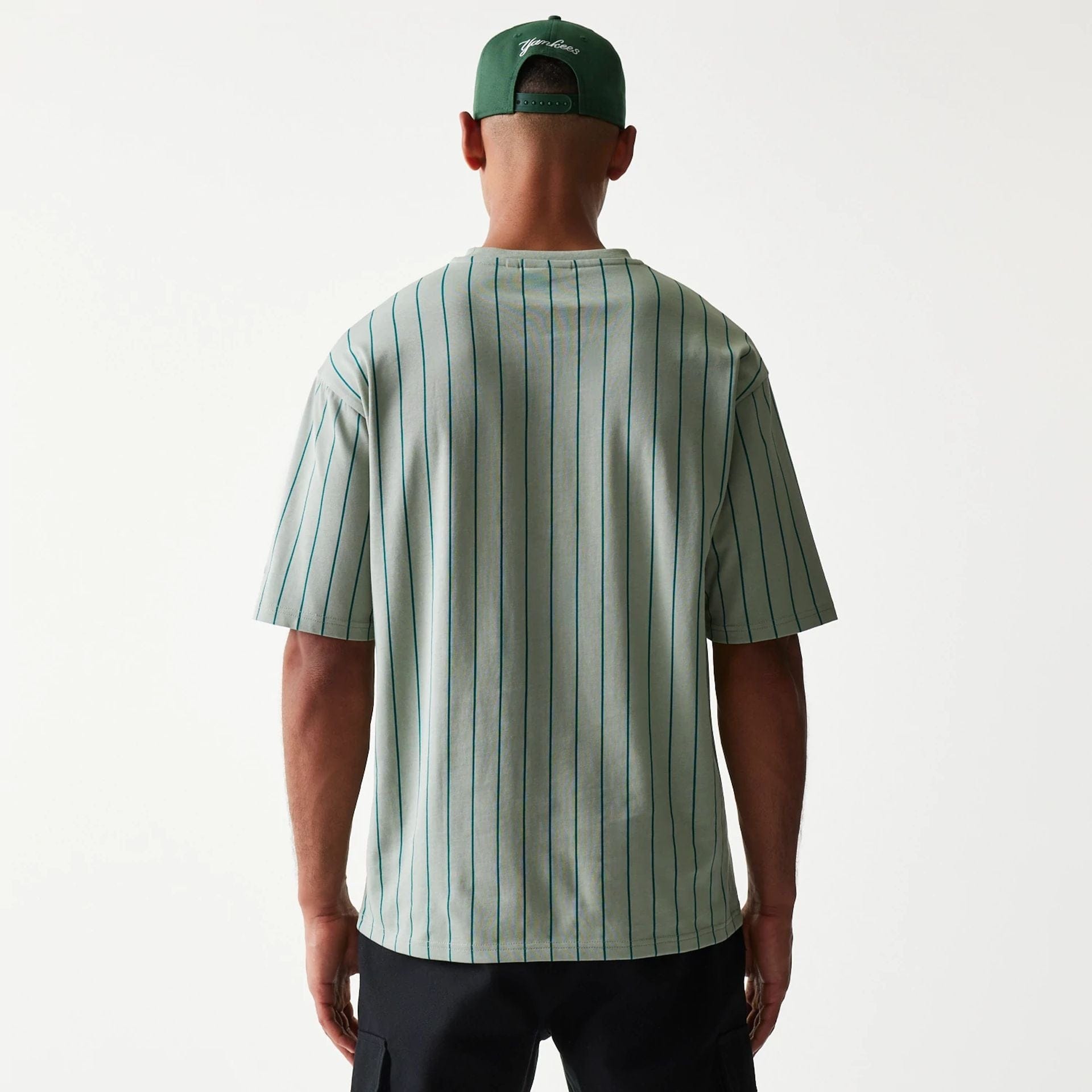 The model is wearing this New Era Pinstripe Oversized T-Shirt in pastel green. 2