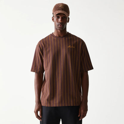 The model is wearing this New Era Pinstripe Oversized T-Shirt in brown. 1