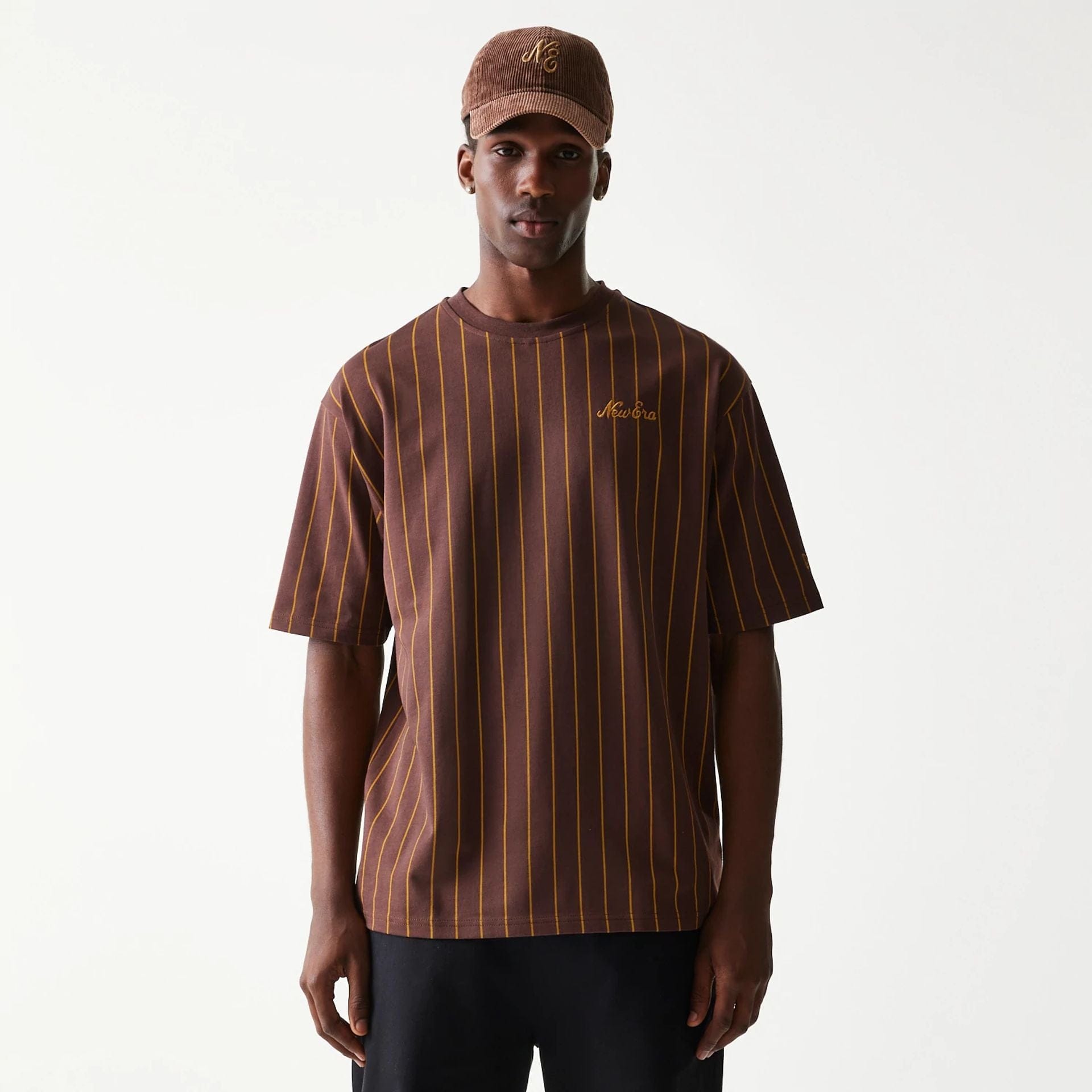 The model is wearing this New Era Pinstripe Oversized T-Shirt in brown. 1