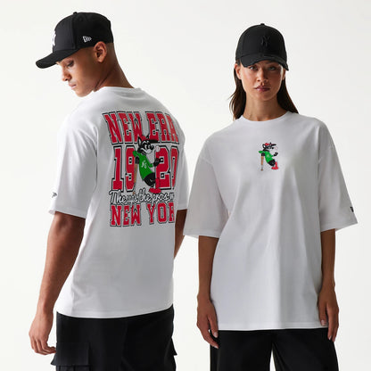 New Era Baseball Cat Character Graphic White Oversized T-Shirt, front and back view showing a playful cat graphic with a bat in green on the front and large red New Era 1920 lettering with the cat on the back, worn by models with black caps.