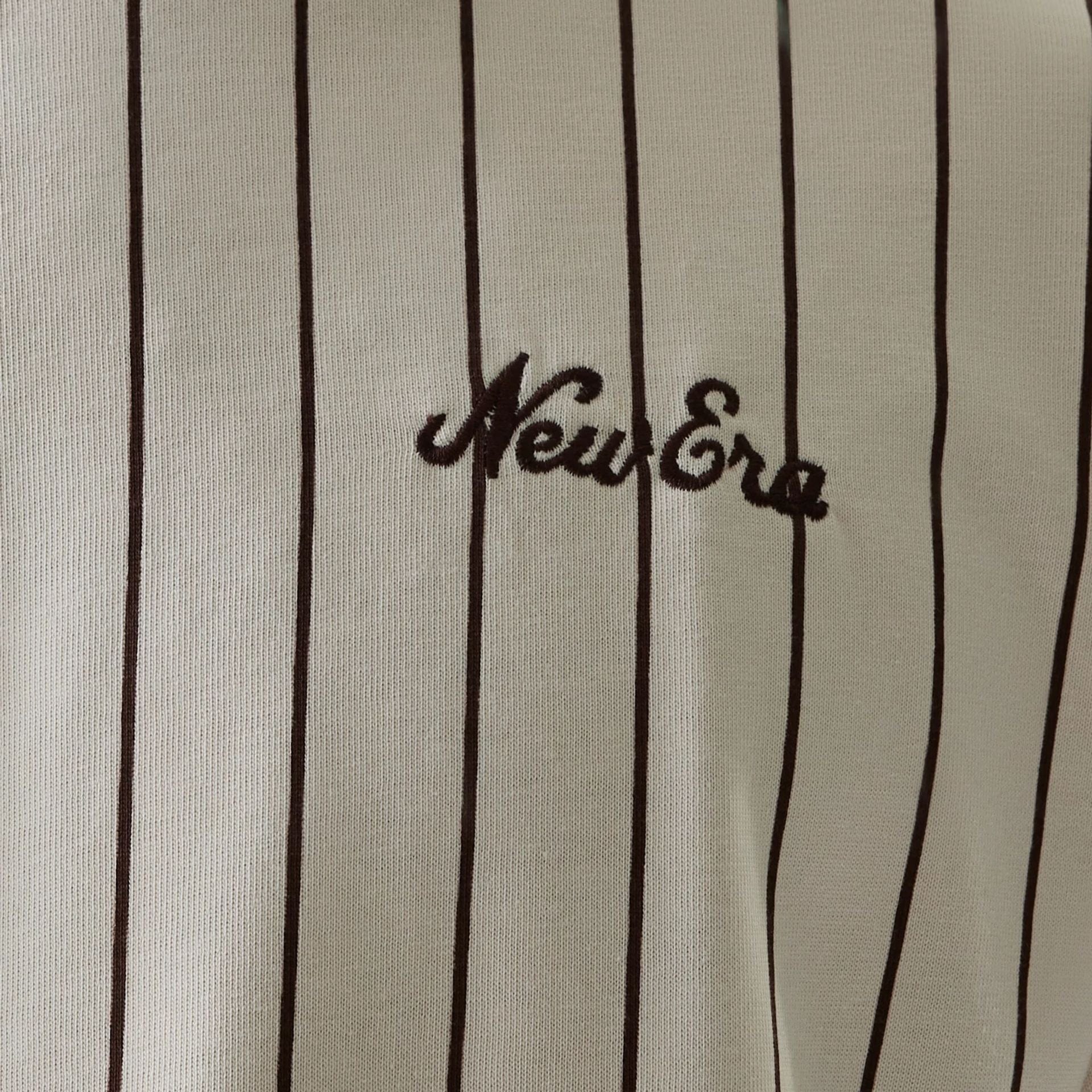 The model is wearing this New Era Pinstripe Oversized T-Shirt in light beige. 8