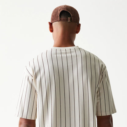 The model is wearing this New Era Pinstripe Oversized T-Shirt in light beige. 4