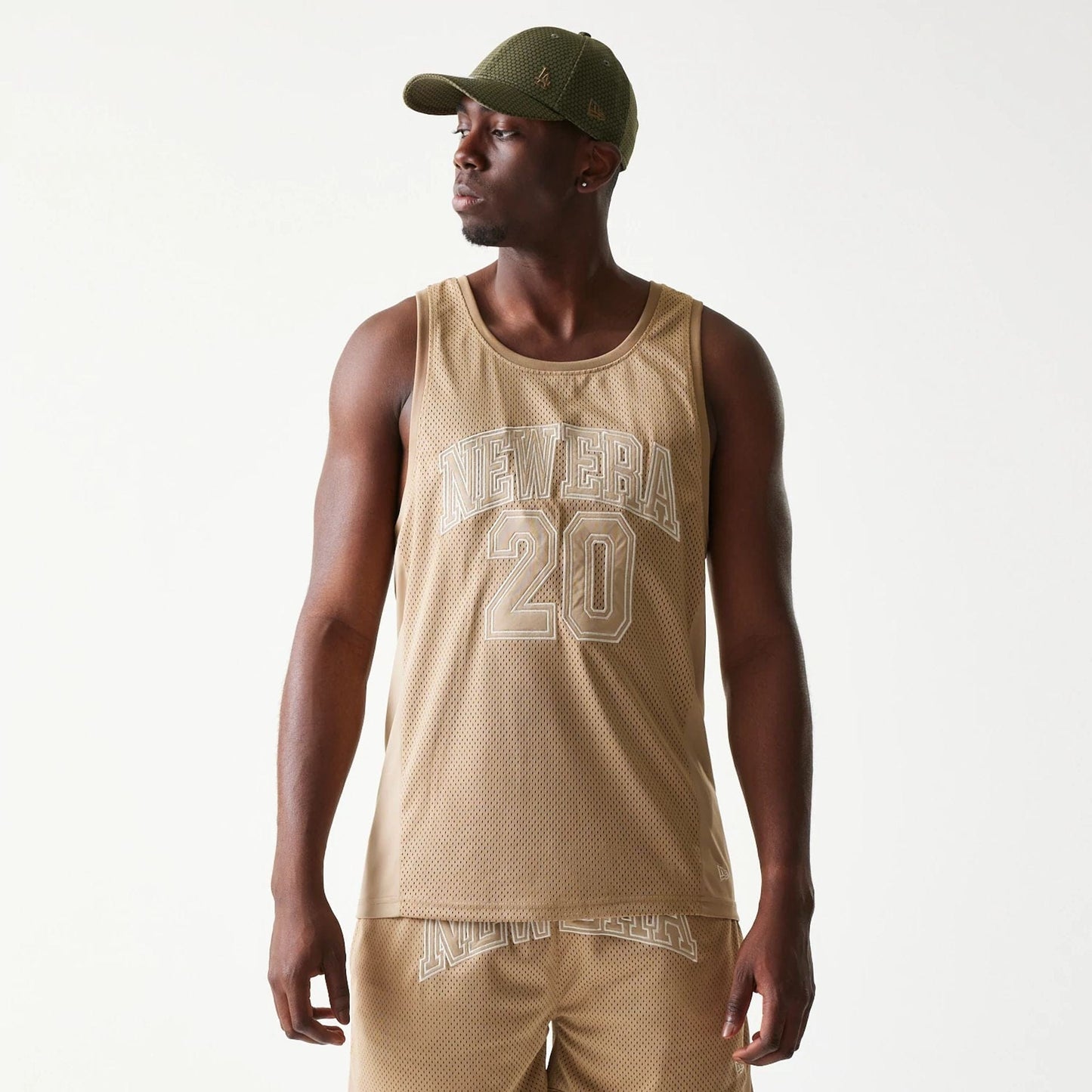 The model is wearing this New Era Mesh Tank Top in light beige. 3