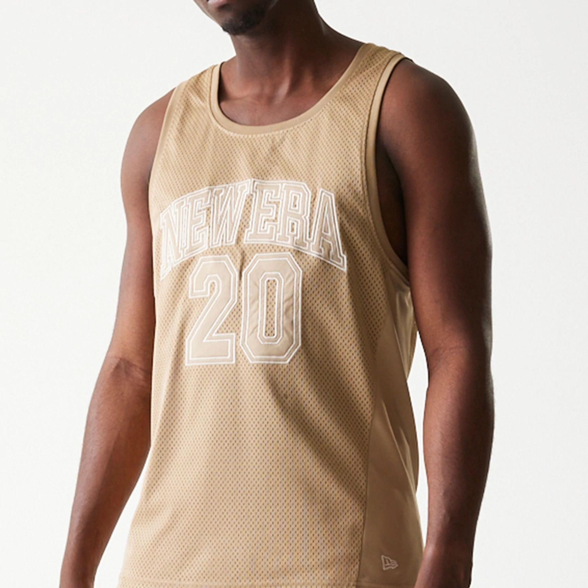 The model is wearing this New Era Mesh Tank Top in light beige. 5